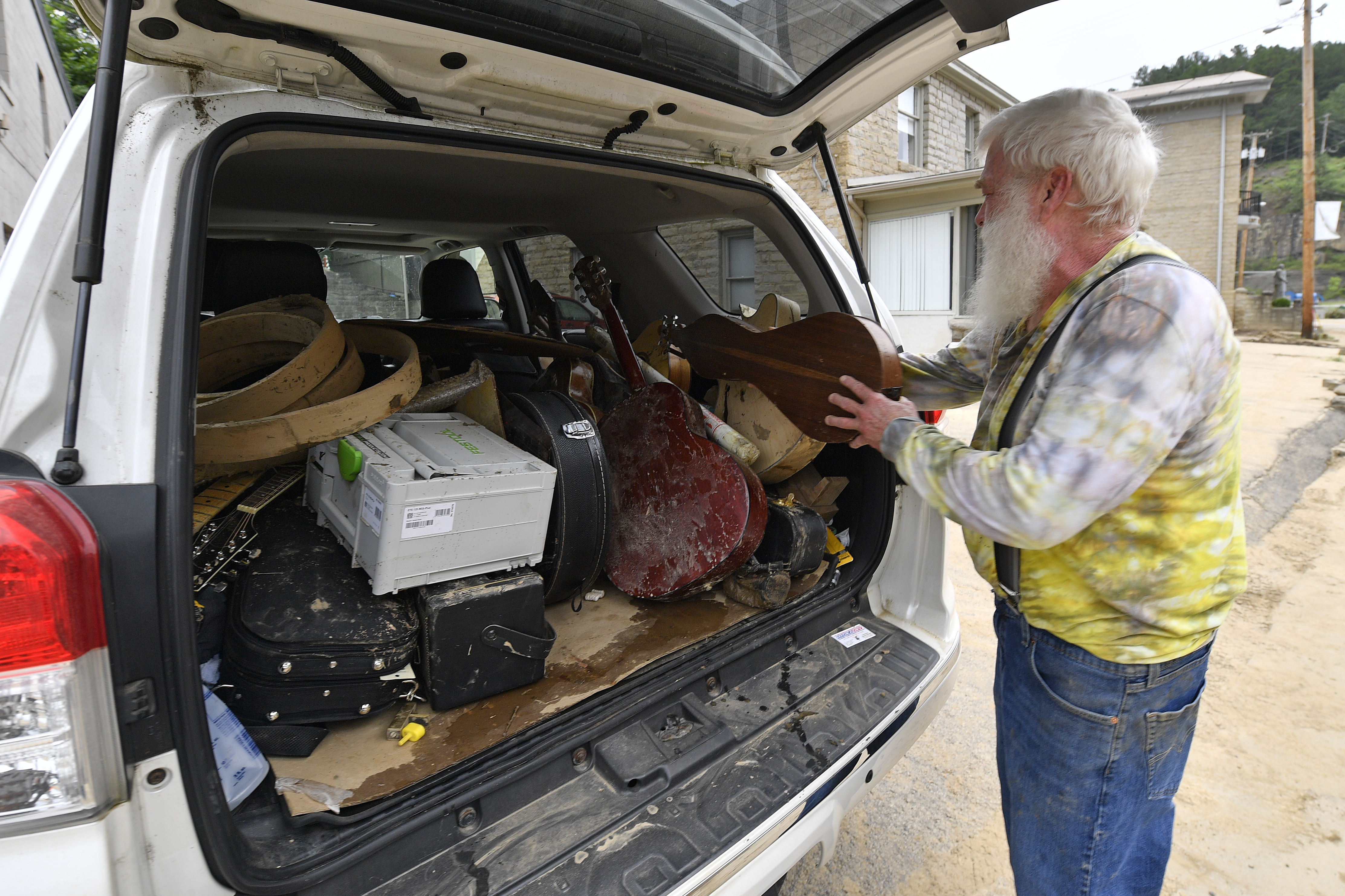 Paul Williams, Luthery Instructor at the Applachian School of Luthery loads instruments he hopes to save that were damaged in the floodwaters of Troublesome Creek into his truck in Hindman, Ky., Sunday.