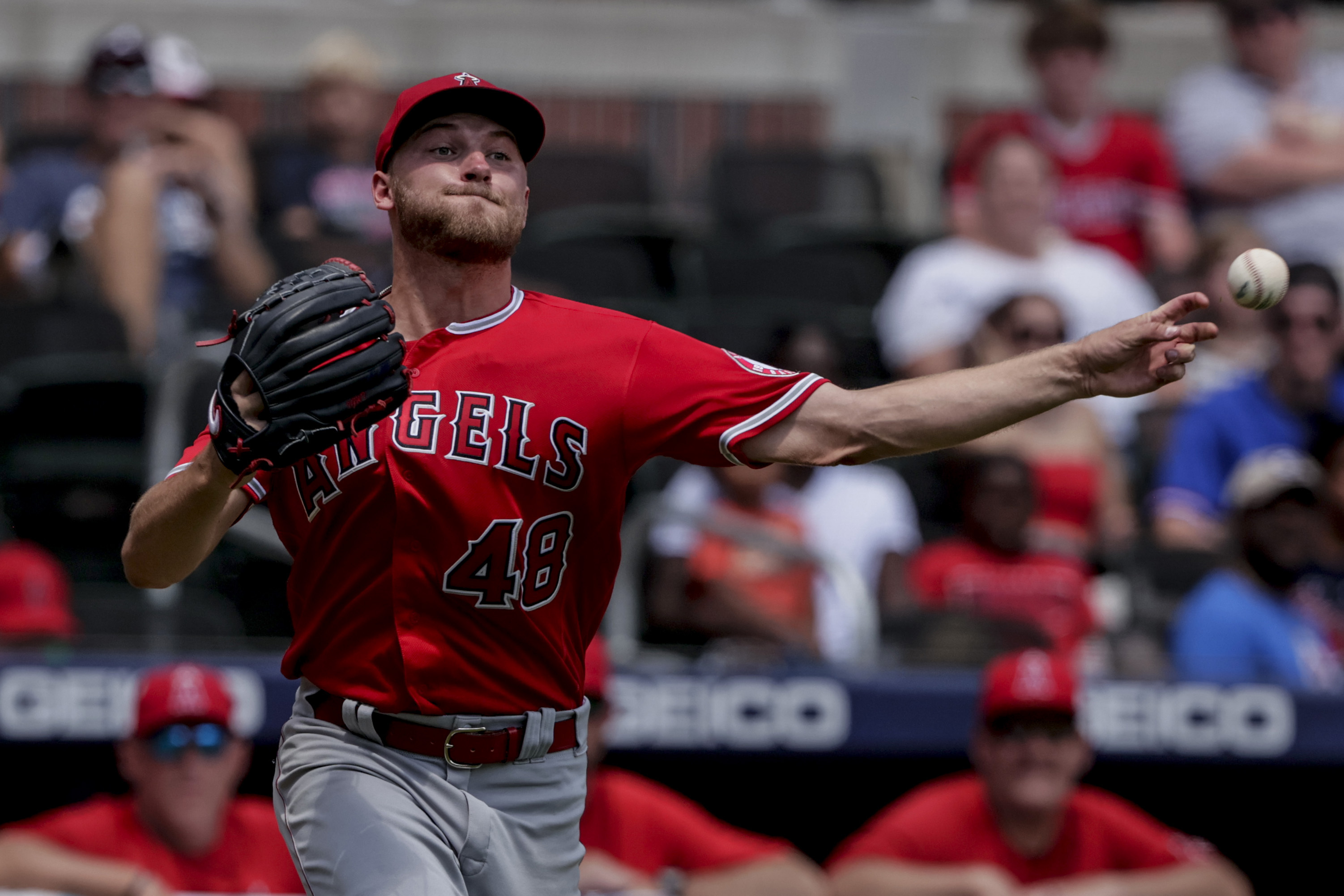 Los Angeles Angels starting pitcher Reid Detmers makes an errant throw to first on a hit by Atlanta Braves' Guillermo Heredia during the fifth inning of a baseball game Sunday, July 24, 2022, in Atlanta. 