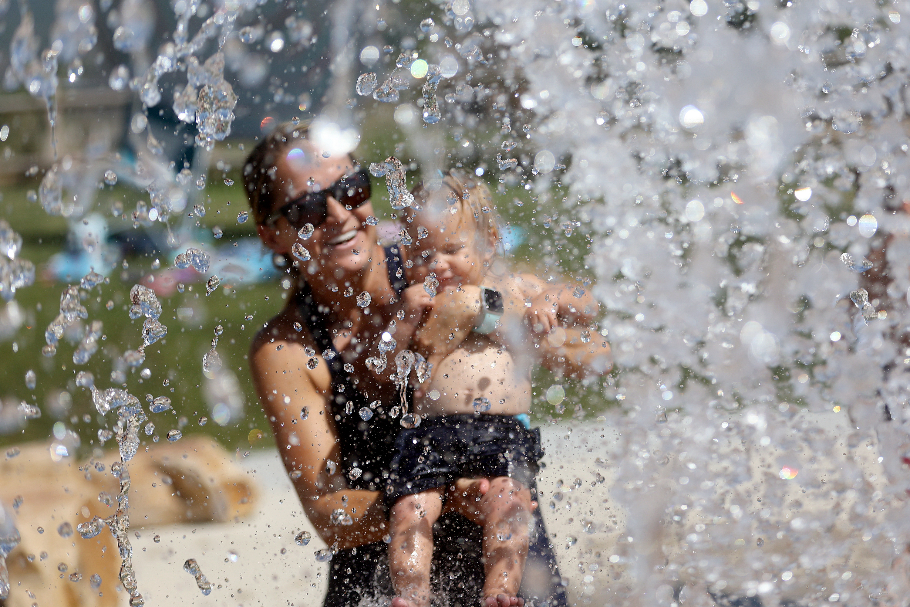 Joana Abeel holds her daughter, Penelope Abeel, at the Draper City Splash Pad during a heat wave in Draper on July 20. July was the hottest month on record for Salt Lake City.