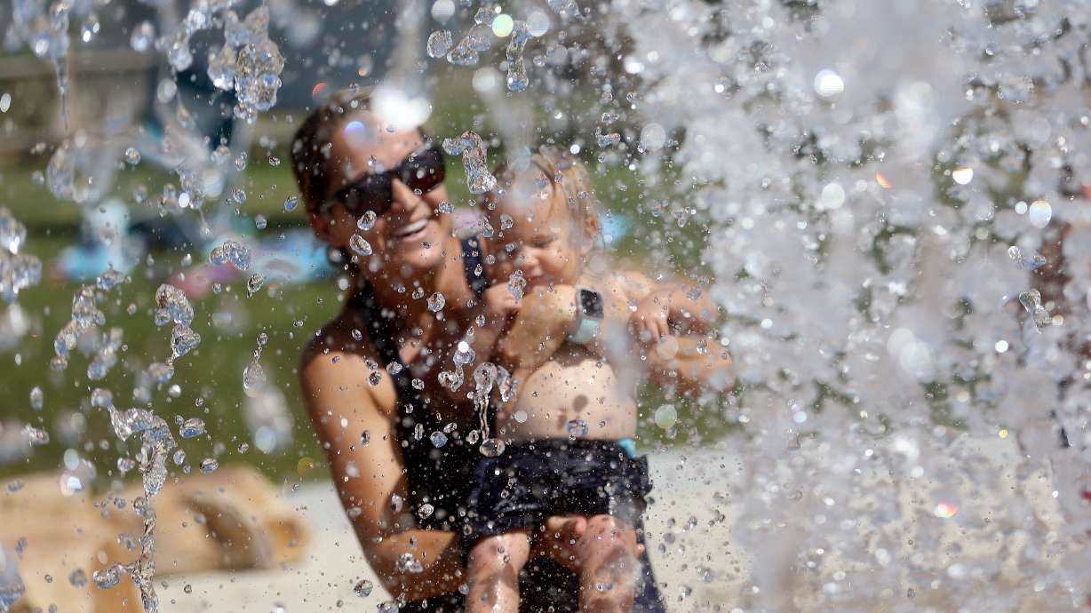 Joana Abeel holds her daughter, Penelope Abeel, at the Draper City Splash Pad during a heat wave in Draper on July 20. July was the hottest month on record for Salt Lake City.