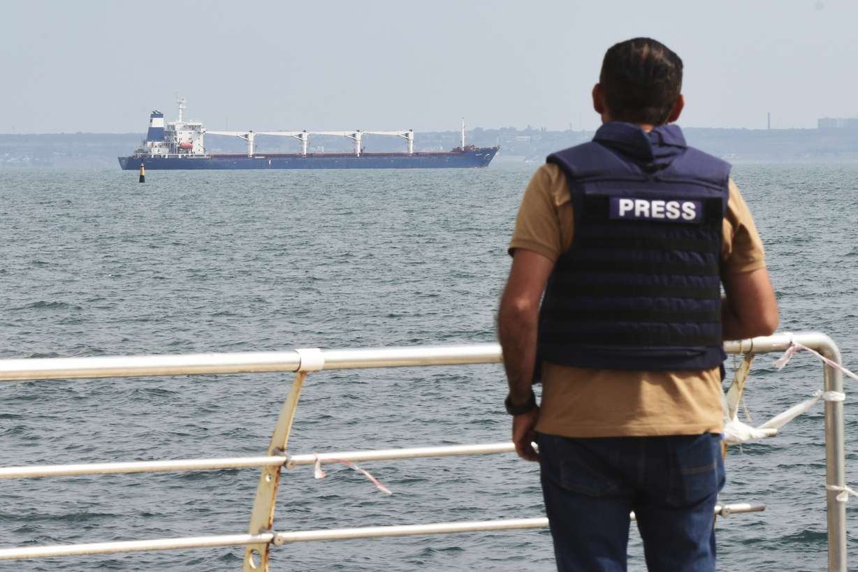 A journalist watches as the bulk carrier Razoni starts its way from the port in Odesa, Ukraine, Monday. According to Ukraine's Ministry of Infrastructure, the ship under Sierra Leone's flag is carrying 26 thousand tons of Ukrainian corn to Lebanon. The first ship carrying Ukrainian grain set off from the port of Odesa on Monday under an internationally brokered deal and is expected to reach Istanbul on Tuesday, where it will be inspected, before being allowed to proceed.