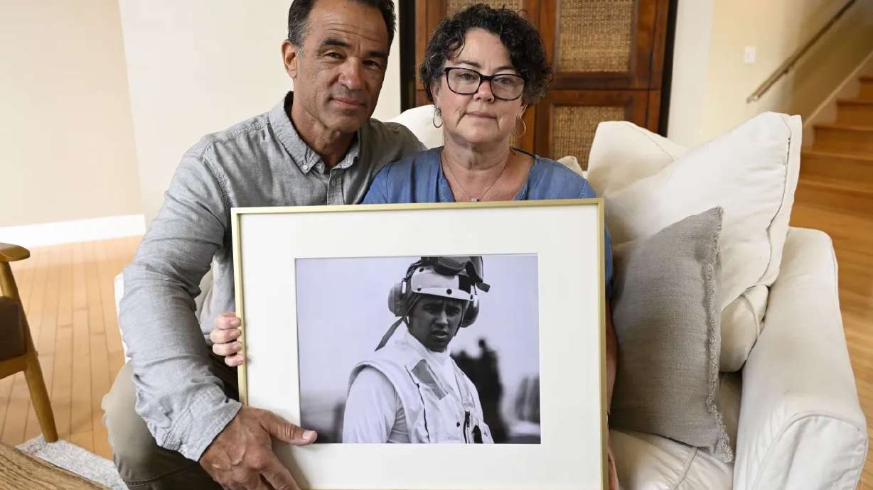 Derek and Suzi Alkonis pose with a photo of their son, Lt. Ridge Alkonis, on June 1, in Dana Point, Calif. Their son, a U.S. Navy lieutenant who was stationed in Japan, is now serving a three-year prison sentence there for a car crash that killed two people. His family and the Navy say he passed out unconscious behind the wheel. Japanese prosecutors and a judge say he was feeling drowsy and should have pulled over.
