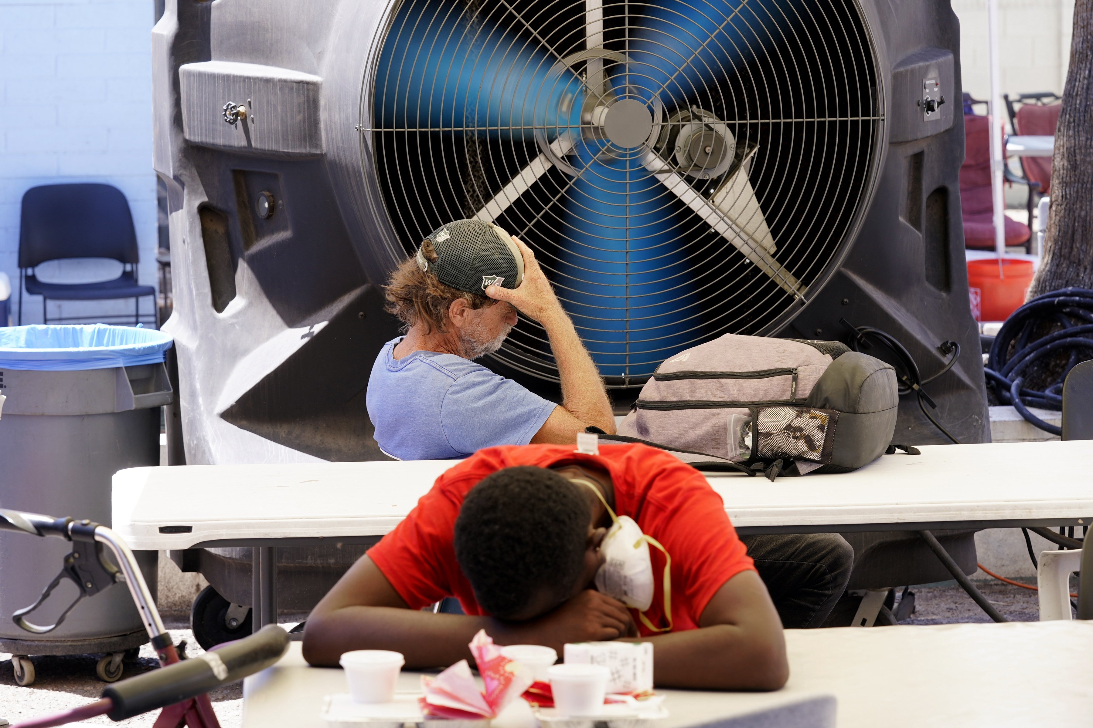People try to keep cool at the Justa Center, a resource center catering to the older homeless population, as temperatures hit 110-degrees, July 19, in Phoenix. The Biden Administration Tuesday, July 26, unveiled a new website, heat.gov, that federal officials hope can help people and local governments beat the heat and keep it from getting deadly. 