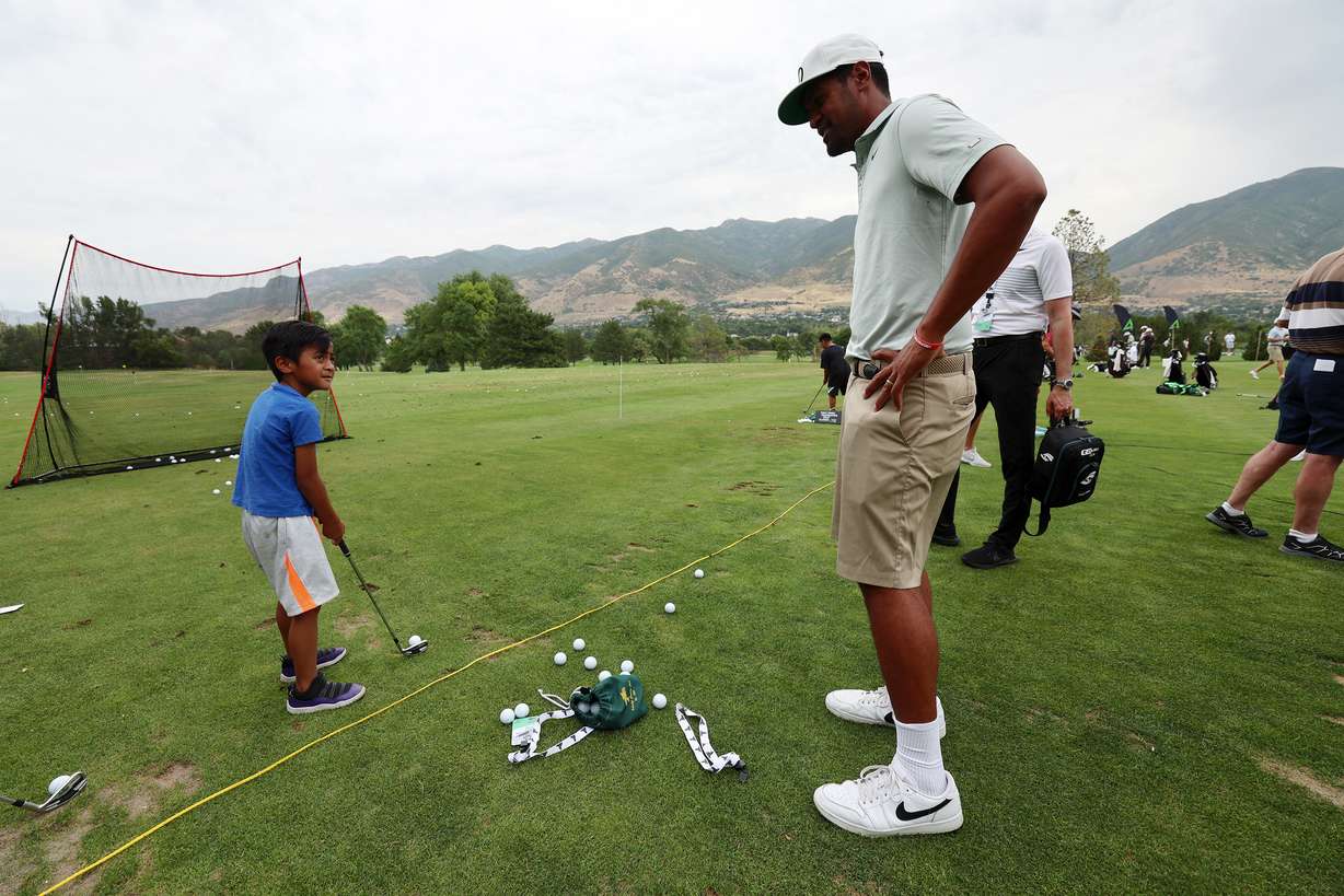 Sage Finau watches her father, Tony, practice his swing at Oakridge Country Club in Farmington during the Tony Finau Foundation Golf Classic on Monday, Aug. 1, 2022.