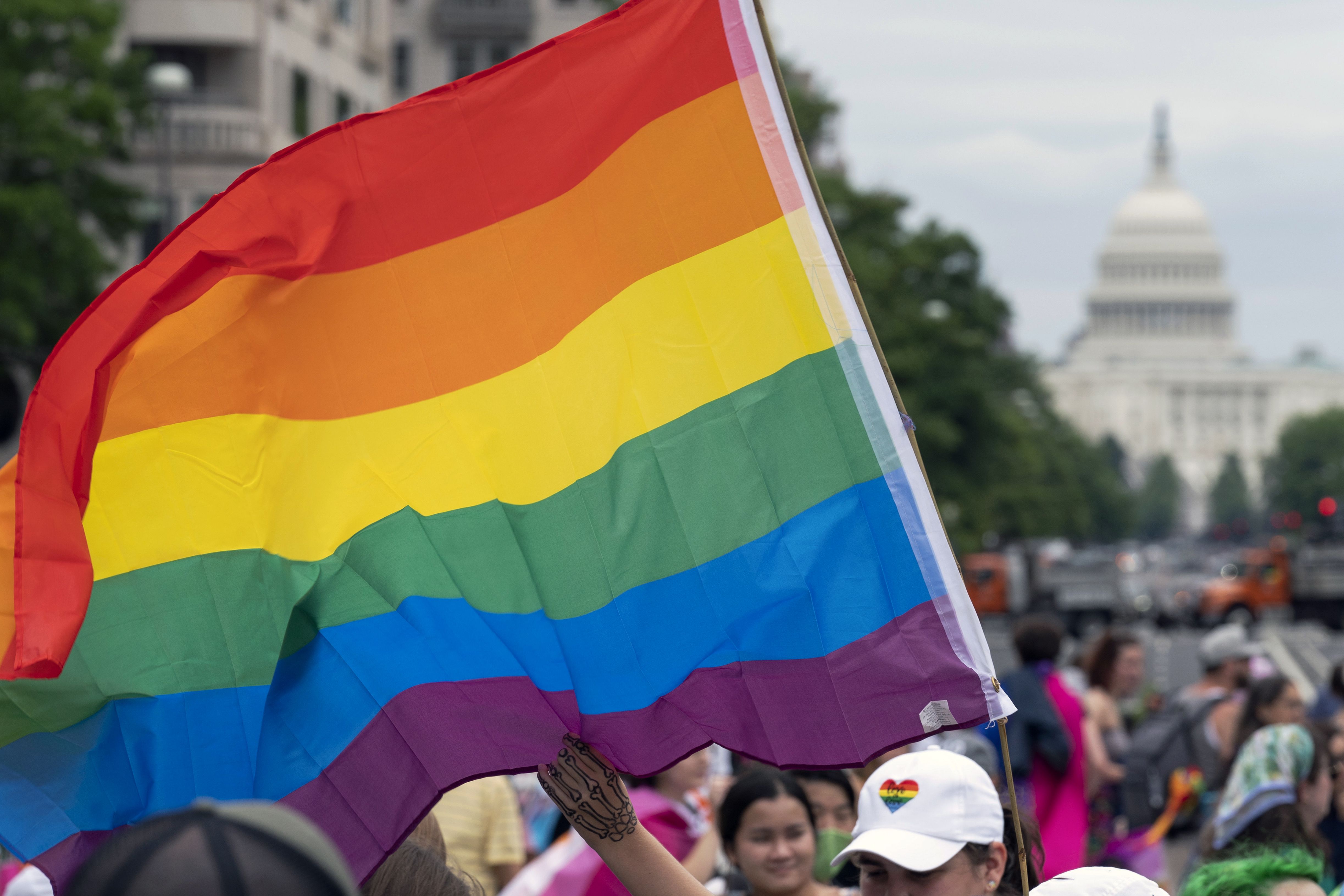 With the U.S. Capitol in the background, a person waves a rainbow flag during a rally in support of the LGBTQIA+ community at Freedom Plaza, June 12, 2021, in Washington. Utahns dropped off hundreds of signatures at Sen. Mitt Romney’s Salt Lake City office Monday urging him to vote for a bill that would protect same-sex marriage.