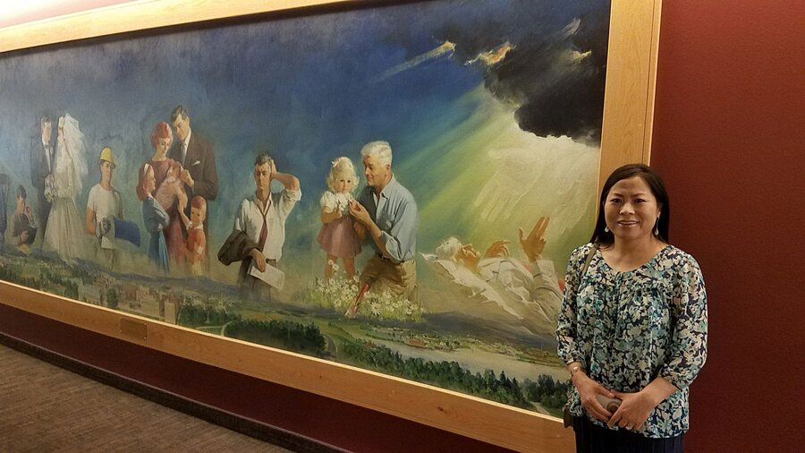 Kyoung Dabell stands in front of a historic mural at BYU-Idaho.