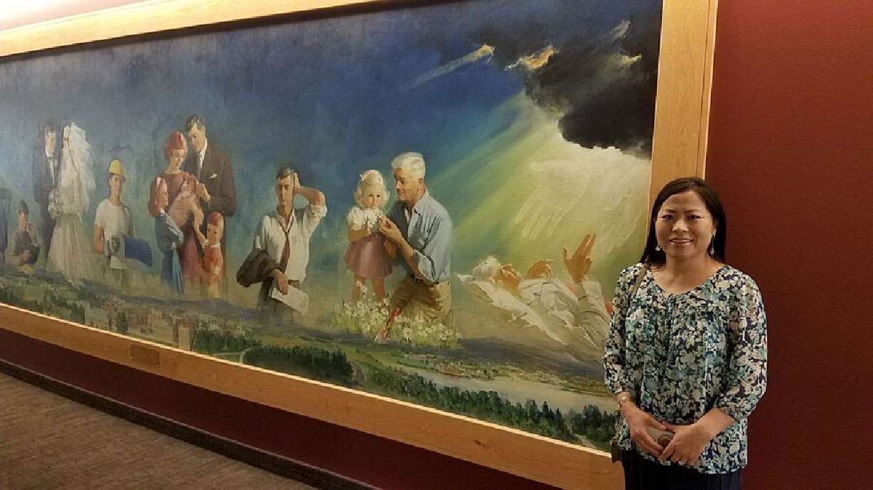Kyoung Dabell stands in front of a historic mural at BYU-Idaho.