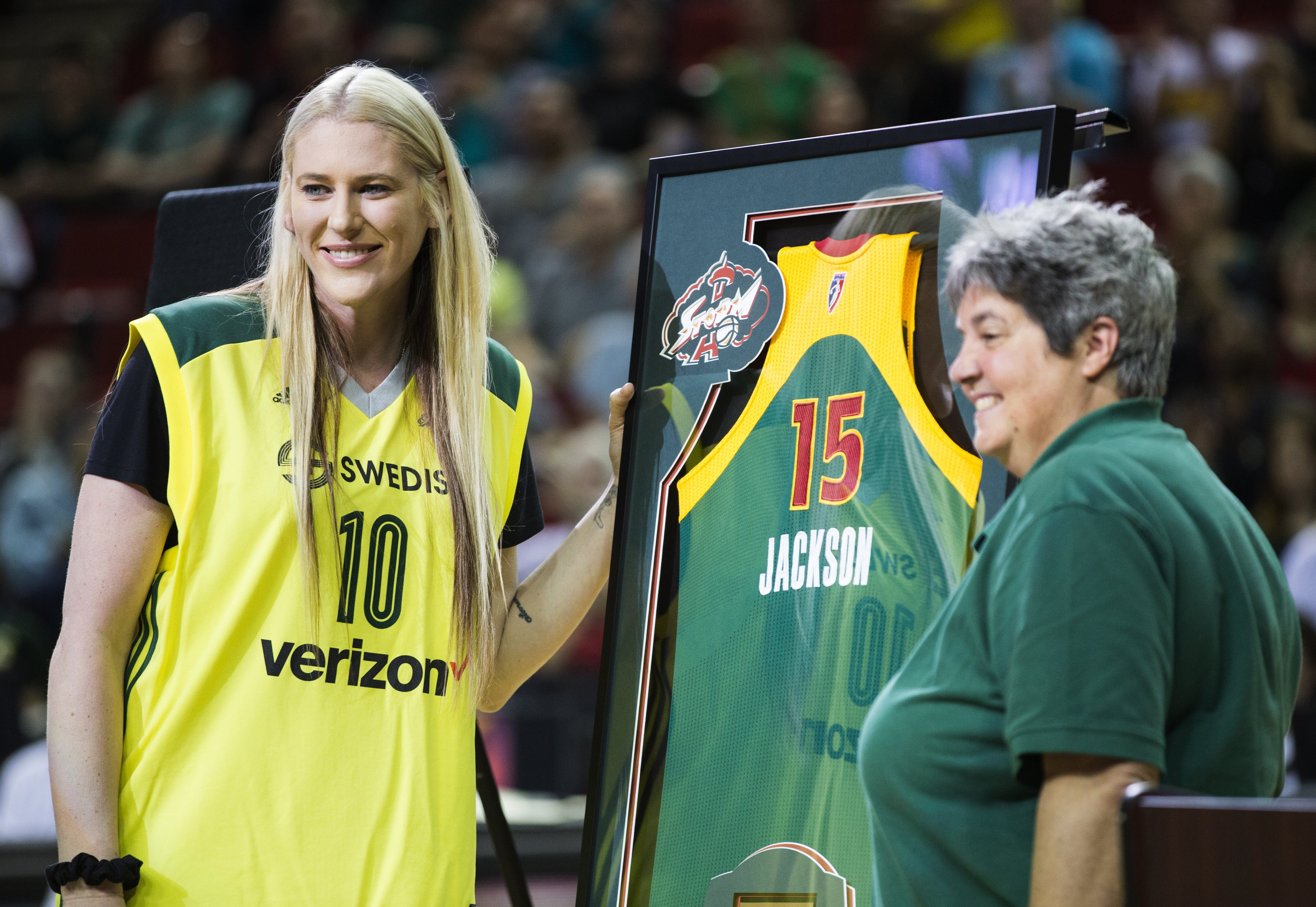 FILE - Lauren Jackson, left, is presented with a jersey by Seattle Storm co-owner Lisa Brummel after the Storm defeated the Washington Mystics 80-51 in a WNBA basketball game, Friday, July 15, 2016, in Seattle. The team formally retired her jersey No. 15. The jersey was unveiled in the arena's rafters, next to the two banners signifying the WNBA championships she helped win in 2004 and 2010. Jackson is savoring every minute of her basketball comeback, in 2022, even though the battle-tested Australian hoops icon knows she can't do things that once captivated fans before retiring from the sport in 2016.