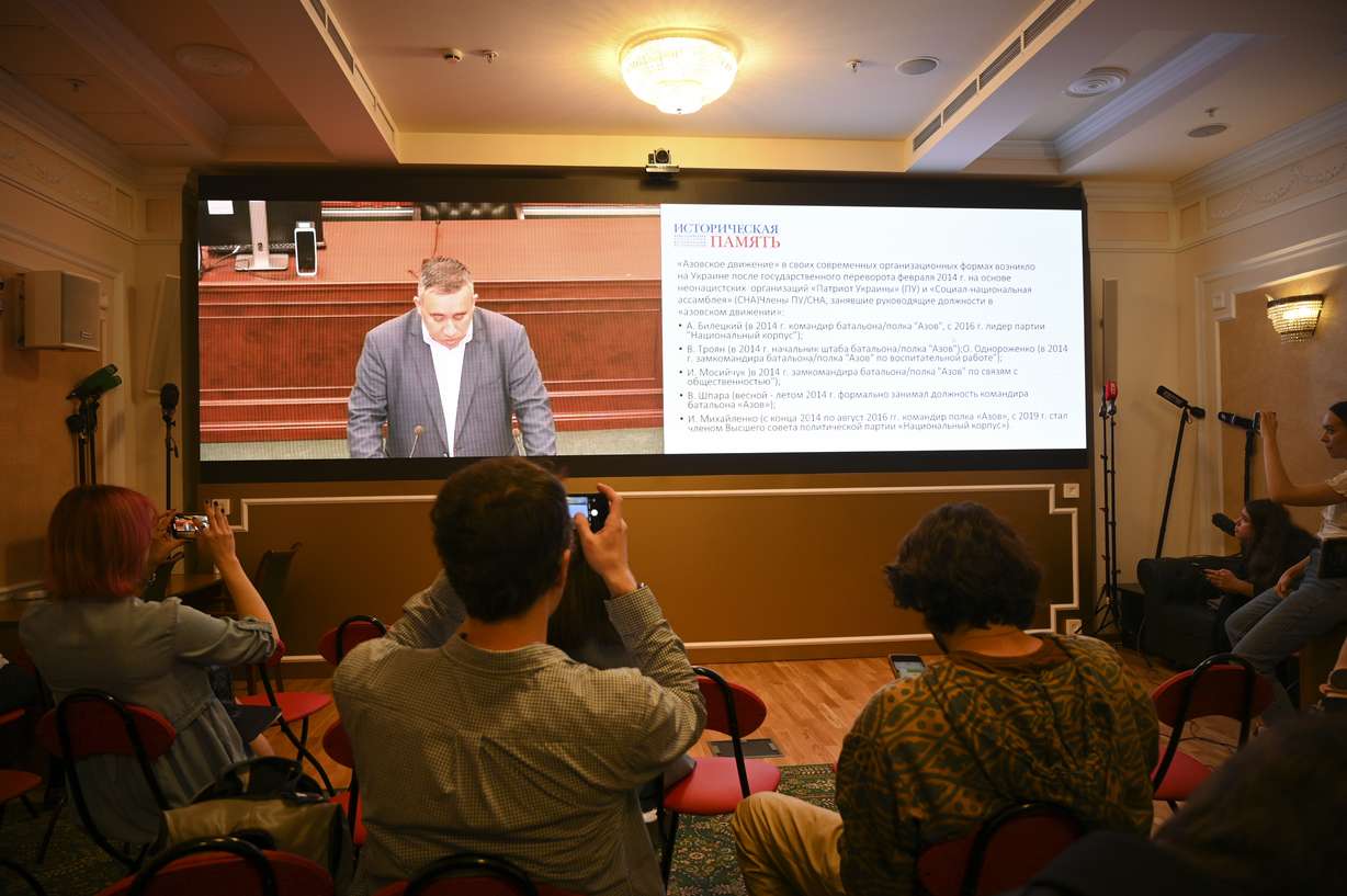 Journalists watch the broadcast of the speech of the expert from the Historical Memory Foundation Alexander Dyukov during a session at the Russian Supreme Court in a broadcast room in Moscow, Russia, Tuesday. The court is considering the request of General Prosecutor's Office to classify Ukrainian Azov battalion as 'terrorist' organization and the ban on its activities in Russia.