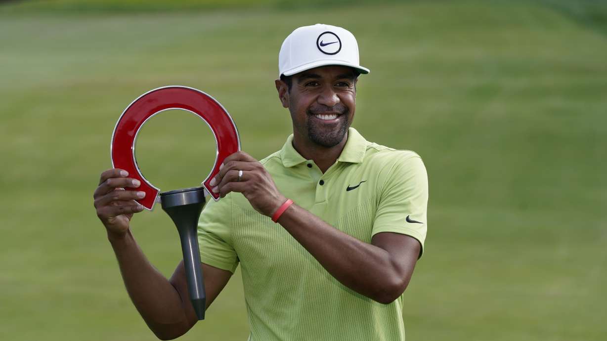 Tony Finau holds the winner's trophy after the final round of the Rocket Mortgage Classic golf tournament, Sunday, July 31, 2022, in Detroit.