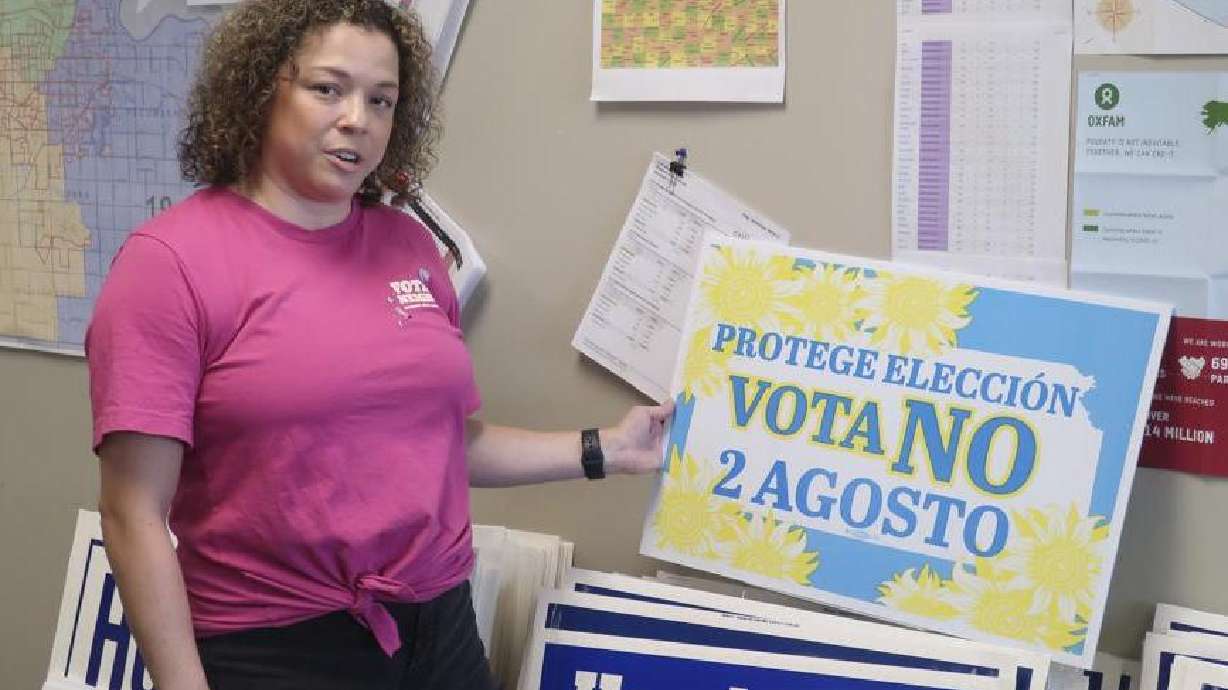 Jessica Porter, communications chair for the Shawnee County, Kansas, Democratic Party, discusses a sign in Spanish urging voters to oppose a proposed amendment to the Kansas Constitution to allow legislators to further restrict or ban abortion, July 15, in Topeka, Kansas. Kansas voters have protected abortion rights by rejecting a measure that would have allowed the Republican-controlled Legislature to tighten abortion restrictions or ban it outright.