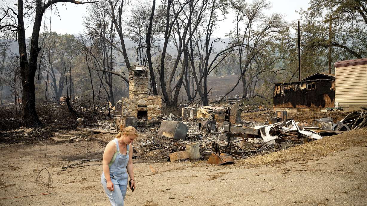 Sydney Corrales passes a lodge that burned during the McKinney Fire, Tuesday in Klamath National Forest, Calif.