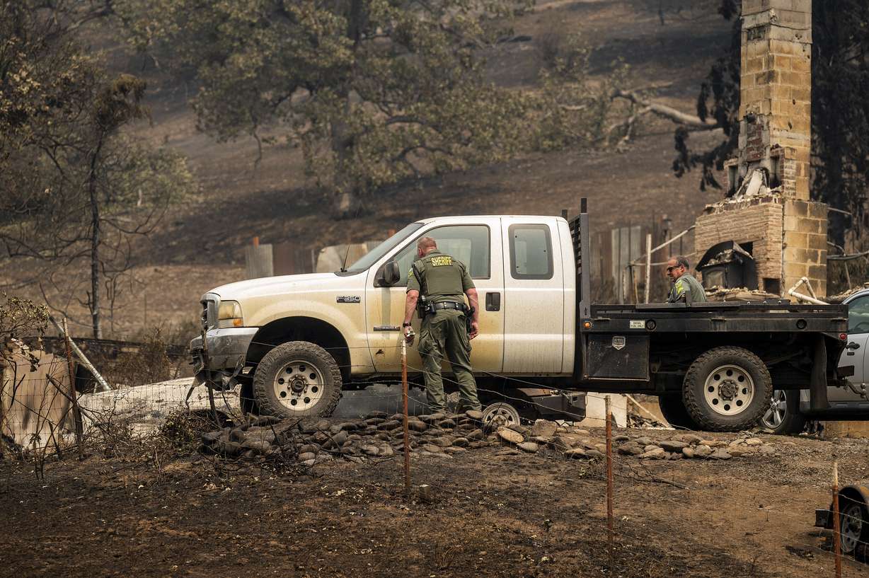 Sheriff's deputies search a scorched residence following the McKinney Fire on Tuesday in Klamath National Forest, Calif. Their team did not find any fire victims at the property.