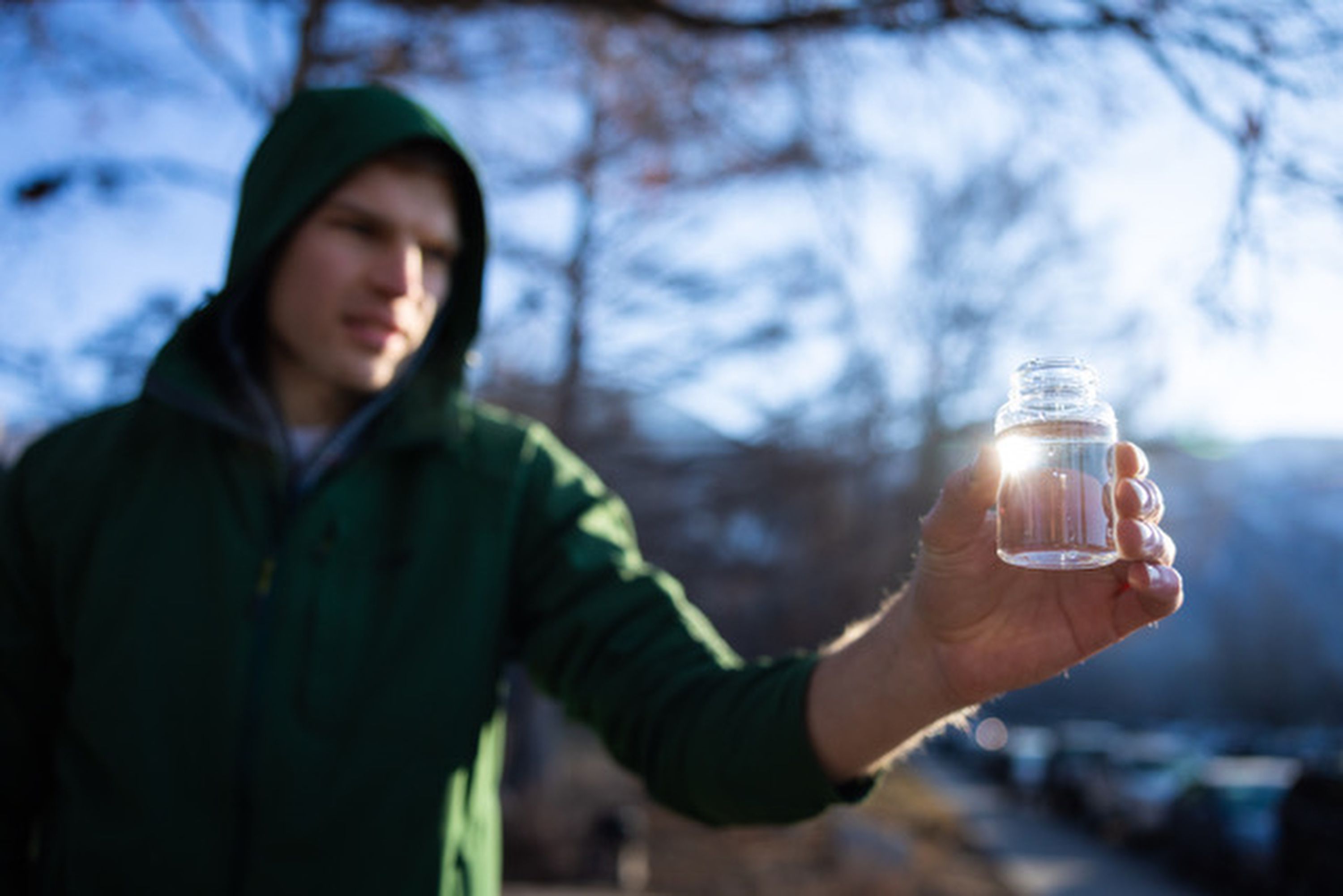 A BYU engineering student checks on the filtered water after cleaning it through a new water filtration device at the duck pond south of campus in Provo on Feb. 8.
