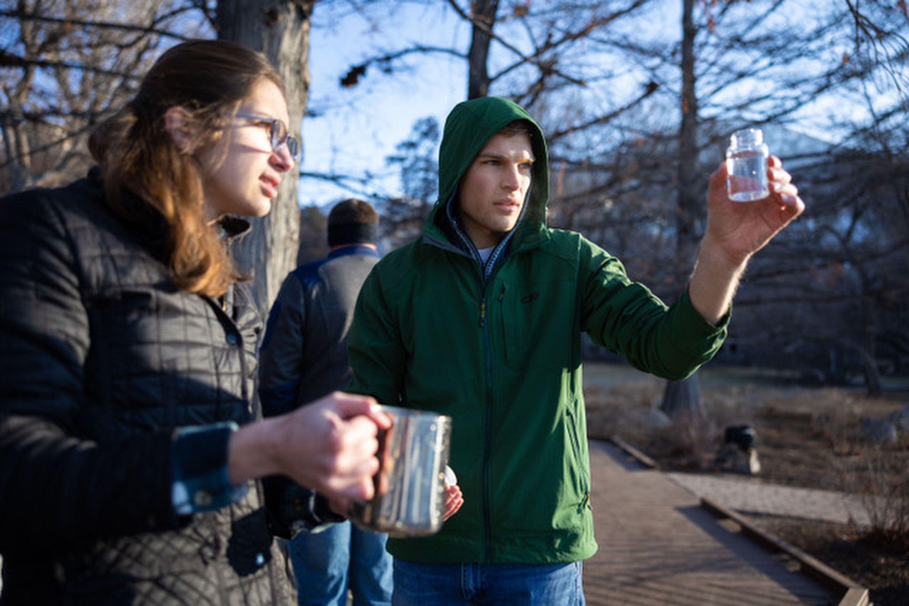 Two BYU engineering students check on the filtered water after cleaning it through their new device at the duck pond south of campus in Provo on Feb. 8.