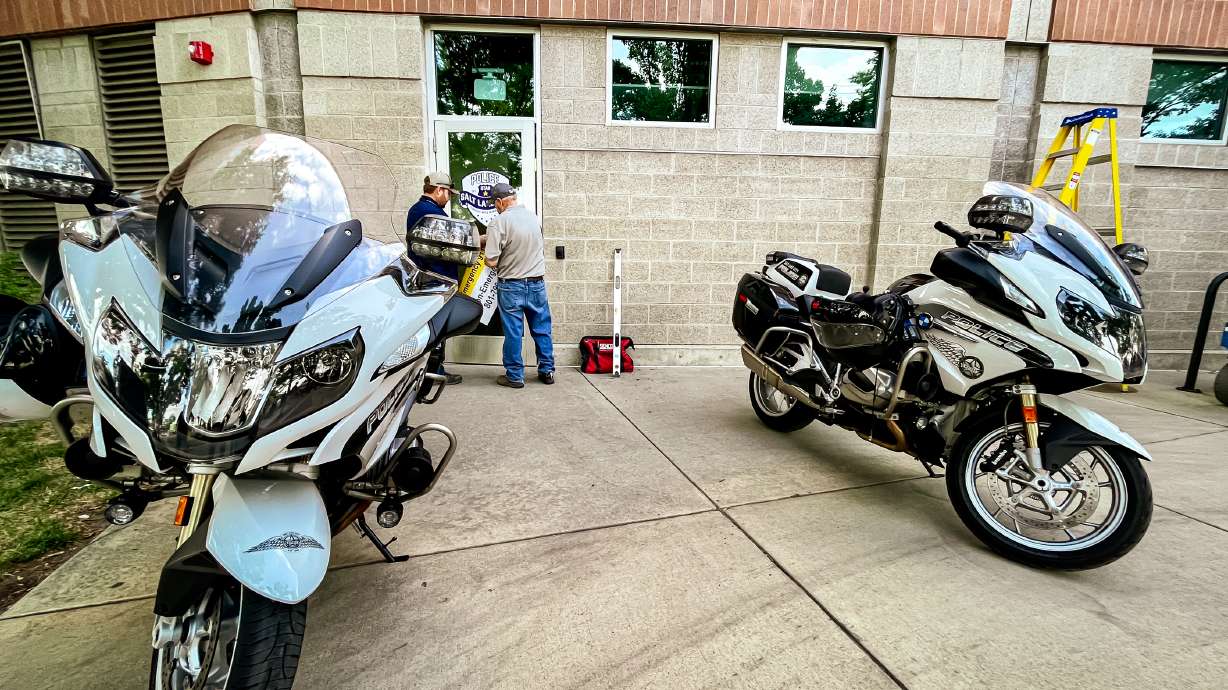 City employees place a Salt Lake City Police Department decal on the door of a new police substation at Smith's Ballpark Thursday.