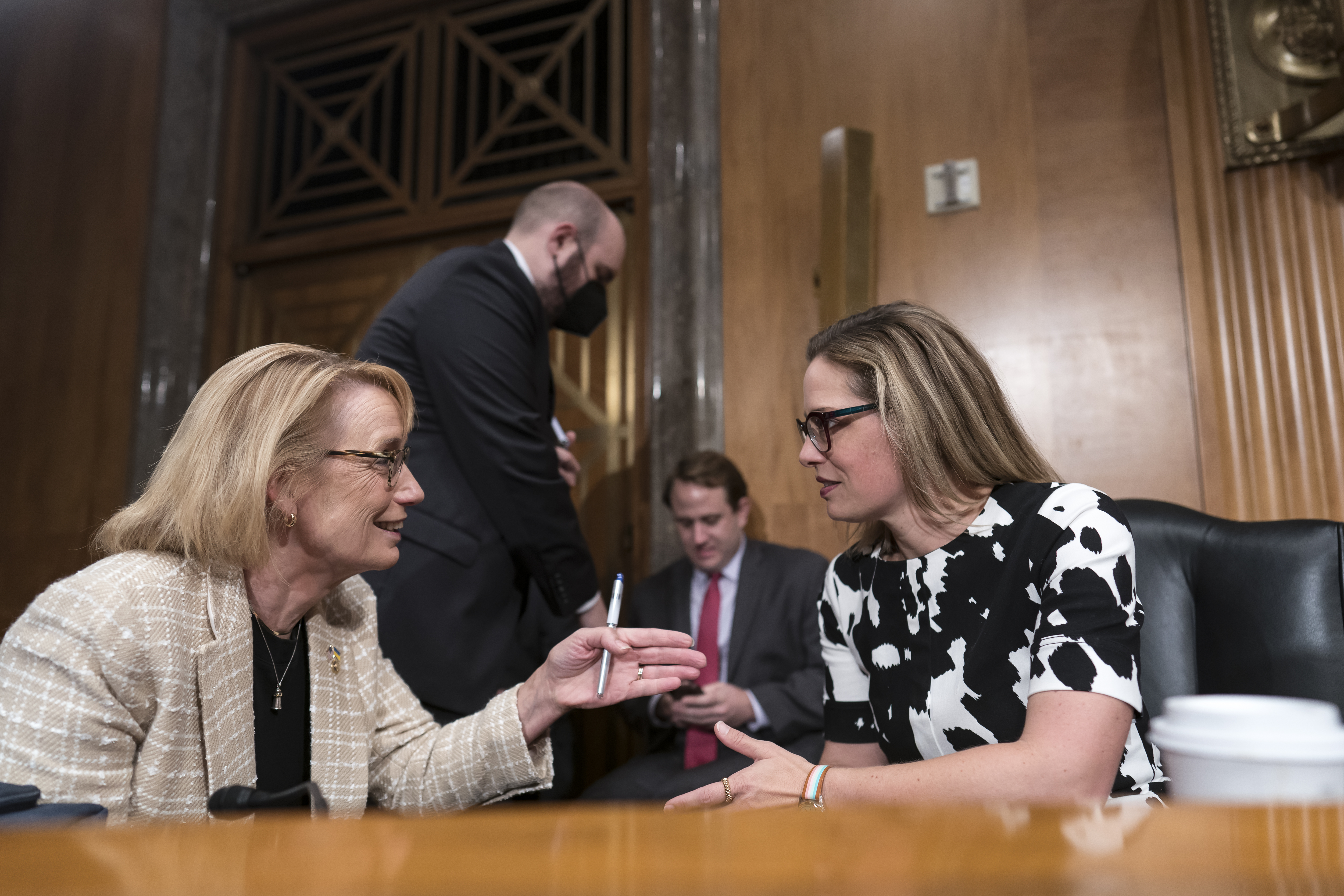 Sen. Maggie Hassan, D-N.H., left, speaks with Sen. Kyrsten Sinema, D-Ariz., during a meeting at the Capitol in Washington, Wednesday. Sinema said on Thursday she agreed to "move forward" on a $430 billion drug pricing, energy and tax bill.