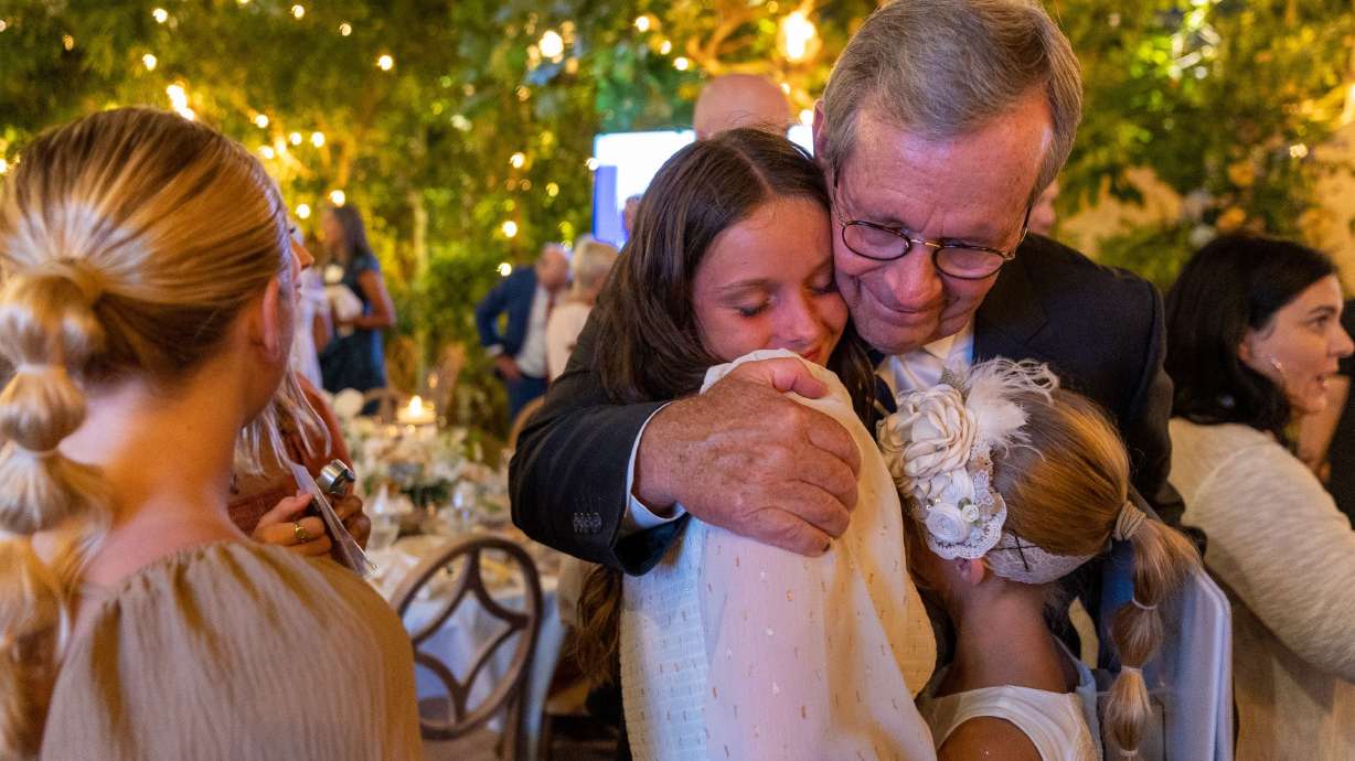 Former Gov. Mike Leavitt hugs his grandchildren Ava Leavitt and Ivy Leavitt during a gala commemorating Western Governors University’s 25th anniversary, where he was honored as one of its founders, at La Caille in Sandy on Thursday.