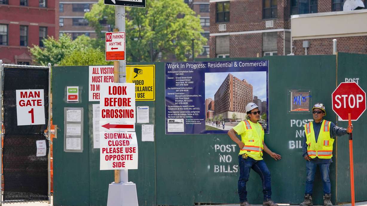 Construction workers help direct traffic outside a building under construction on the Lower East Side of Manhattan, Thursday. On Friday the Labor Department reported employers added 528,000 jobs in July.