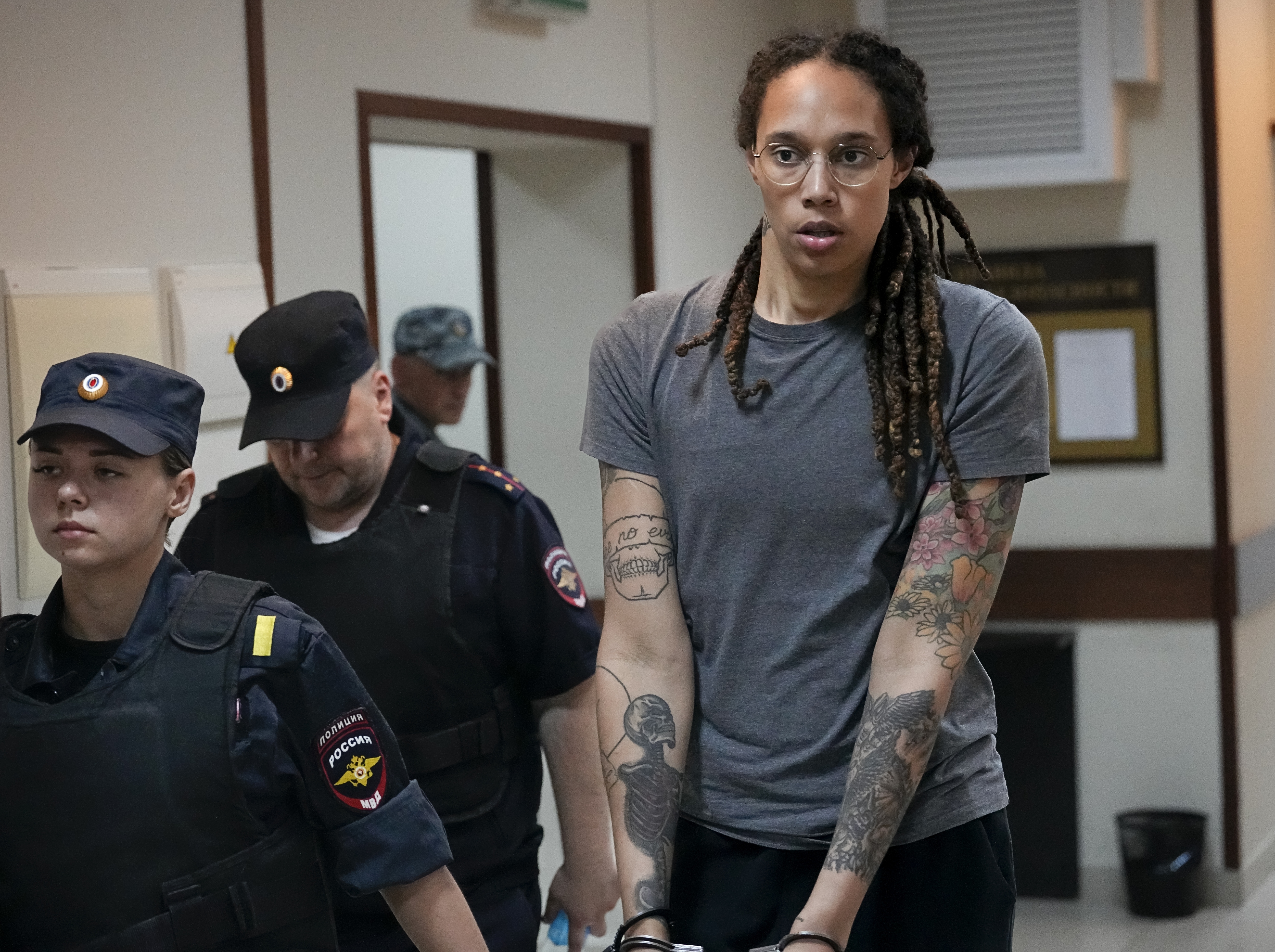 WNBA star and two-time Olympic gold medalist Brittney Griner is escorted from a court room ater a hearing, in Khimki just outside Moscow, Russia, Thursday, Aug. 4, 2022. A judge in Russia has convicted American basketball star Brittney Griner of drug possession and smuggling and sentenced her to nine years in prison. 