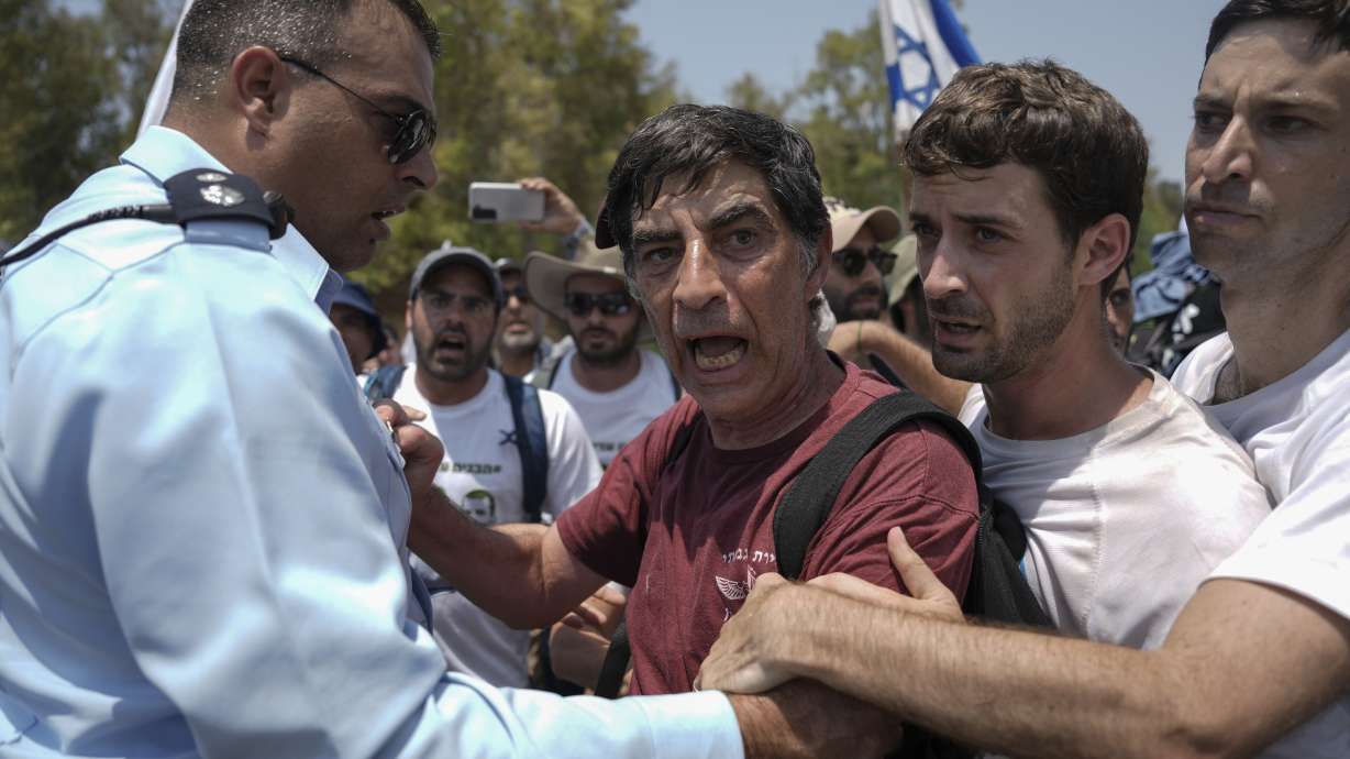An Israeli police officer tries to block Simha Goldin, center, father of Israeli soldier Hadar Goldin, killed during the 2014 conflict in the Gaza Strip, from marching towards the Gaza border near Kibbutz Yad Mordechai, southern Israel on Friday.