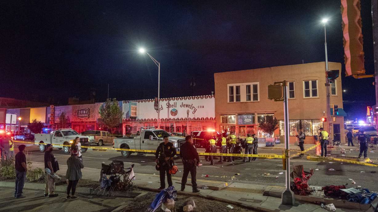 Police section off the site where an SUV came to an abrupt stop after a driver careened through the parade route of the Intertribal Ceremonial Centennial Celebration. in Gallup, New Mexico, Thursday. Police arrested three people who were in a large SUV that drove through a Native American celebration in New Mexico, causing multiple injuries along a parade route crowded with families.