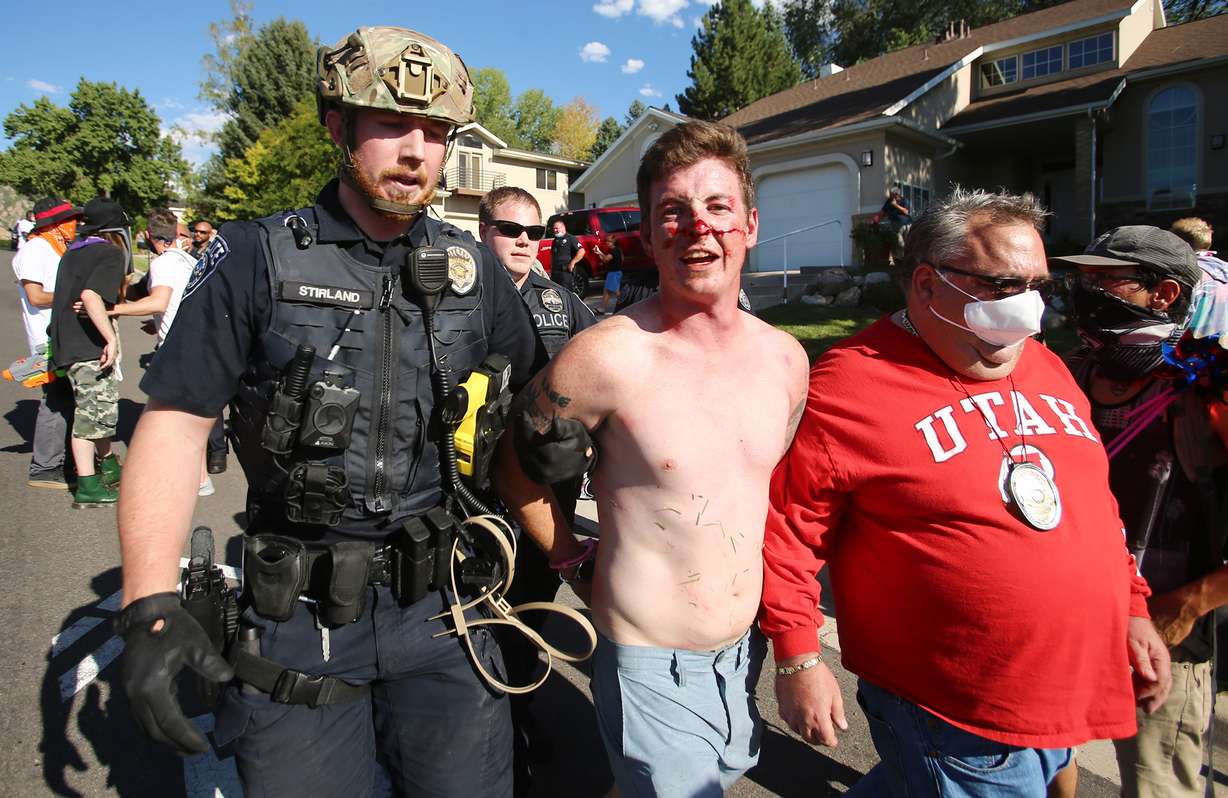 Gabriel Pecoraro, center, is taken into custody by an unidentified officer, left, and Cottonwood Heights Police Chief Robby Russo after police and marchers collided in the streets of Cottonwood Heights on Sunday, Aug. 2, 2020. The group was marching on 6710 South when police blocked them at Cristobal Street and a confrontation ensued. Police said eight or nine protesters were arrested.