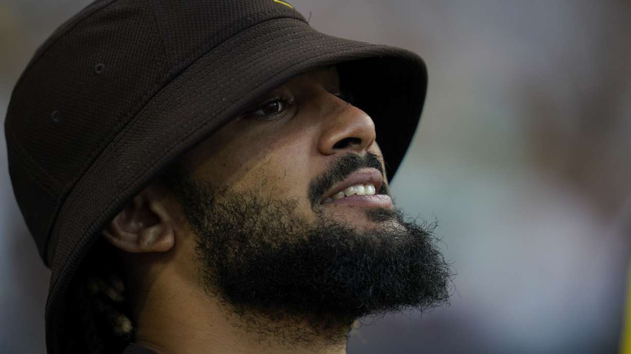 The San Diego Padres' Fernando Tatis Jr reacts in the dugout before the first inning of a baseball game against the Colorado Rockies, Monday, Aug. 1, 2022, in San Diego.