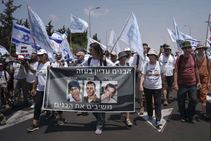 Supporters and family members of Israeli soldiers Hadar Goldin and Oron Shaul who were killed during the 2014 war in the Gaza Strip and captive Israeli civilian Avera Mengistu, march and calling for the return of their remains and the return of Mengistu and other Israelis held in Gaza back to Israel, near Kibbutz Yad Mordechai close to the Israeli Gaza border, Friday. Hebrew on banner reads, "The boys are still in Gaza" and " bringing back the boys."