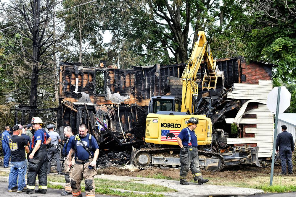 Crews work to demolish a house that was destroyed by a fatal fire on the 700 block of First Street in Nescopeck, Pa., Friday. Multiple people are feared dead after a house fire early Friday in northeastern Pennsylvania, according to a volunteer firefighter who responded and said the victims were his relatives. A criminal investigation is underway, police said.