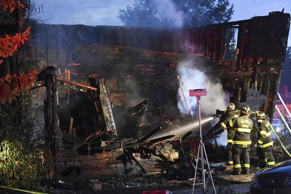 Firefighters work on hot spots in the front section of the home which collapsed during an early morning fatal fire on First Street in Nescopeck, Pa., Friday. The fire was reported around 2:30 a.m. EDT. The cause of the fire remains under investigation.