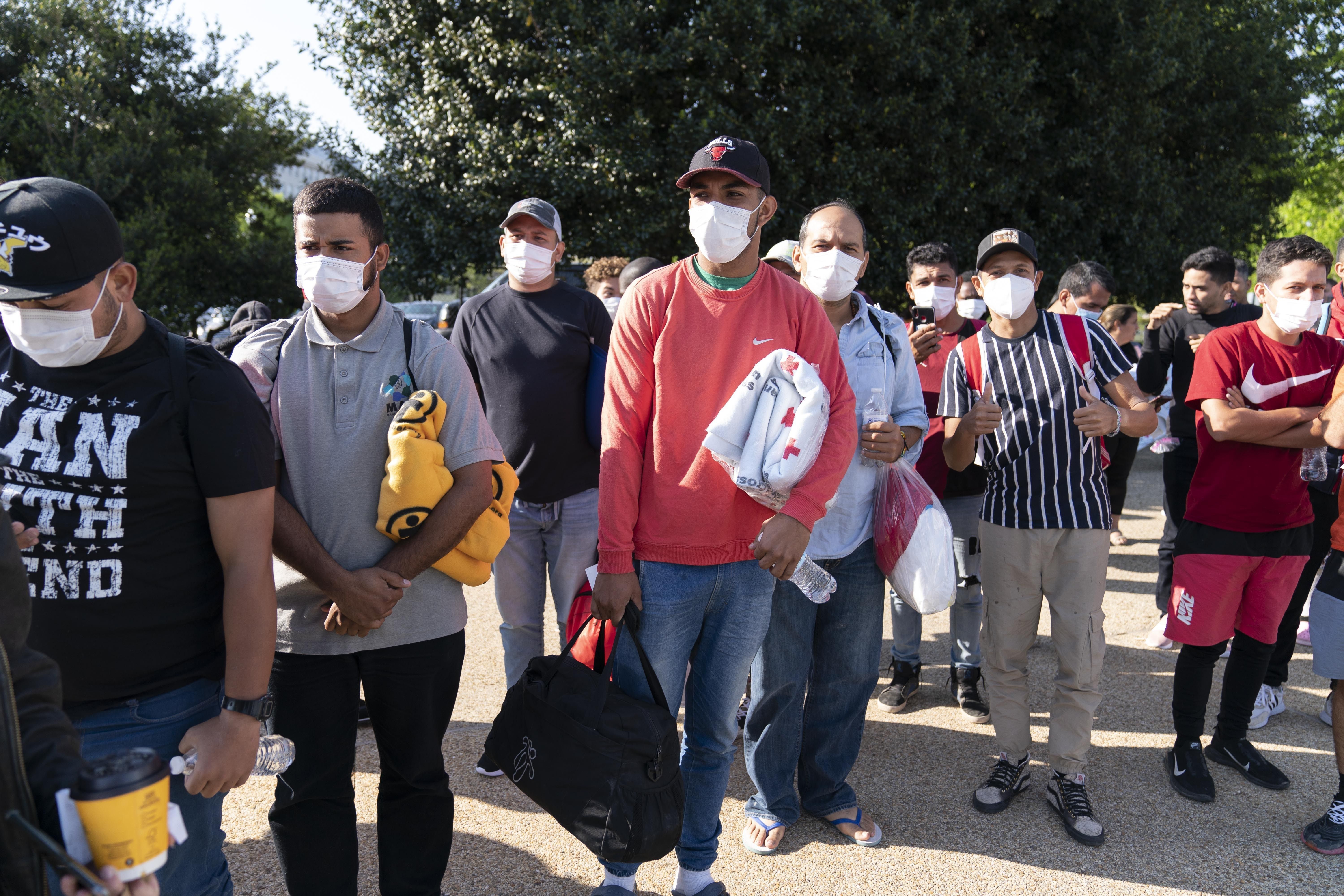Migrants hold Red Cross blankets after arriving at Union Station near the U.S. Capitol from Texas on buses, April 27, in Washington. A bus carrying about 50 migrants arrived in New York City on Friday, part of Texas Gov. Greg Abbott's effort to ship newcomers that arrive at the U.S.-Mexico border to Democrat-run cities on the East Coast.