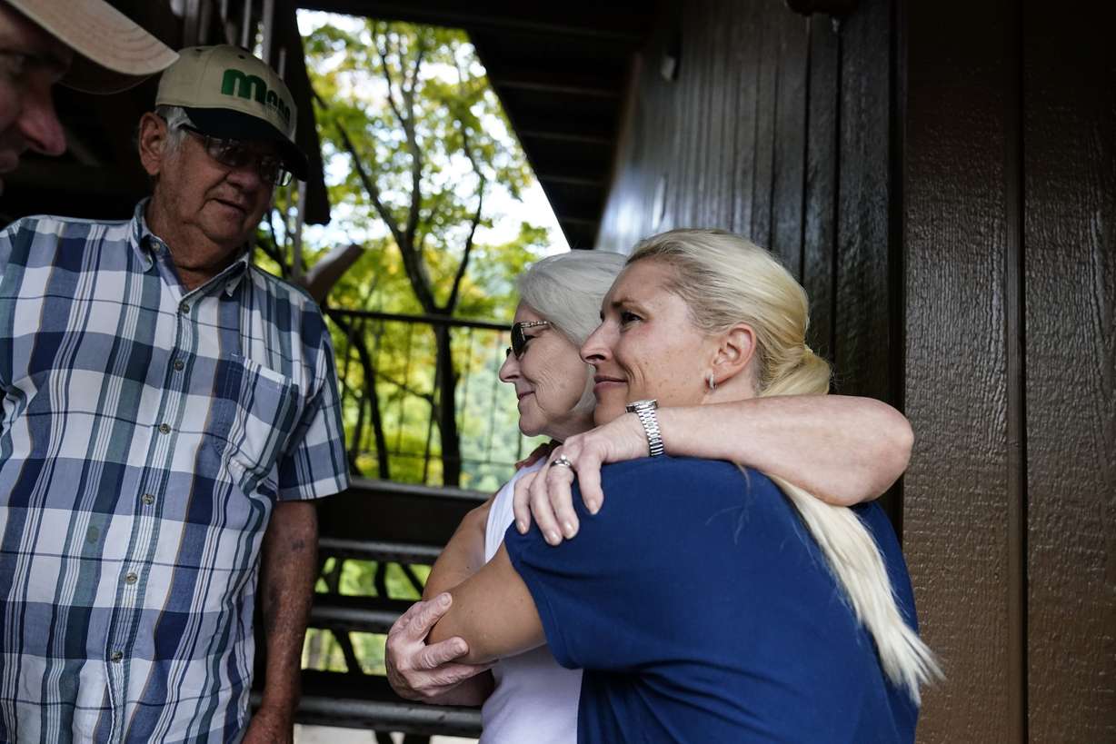 Kentucky Governor Andy Beshear, wife, First Lady Britainy Beshear, right, hugs and talks with Nancy Hall, center, and husband Kadous Hall, left, after she has been displaced by floodwaters at Jenny Wiley State Resort Park Saturday, in Prestonsburg, Kentucky.