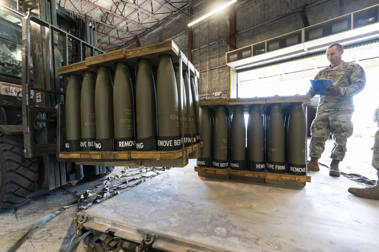 U.S. Air Force Staff Sgt. Cody Brown, right, with the 436th Aerial Port Squadron, checks pallets of 155 mm shells ultimately bound for Ukraine, April 29, at Dover Air Force Base, Del. The Biden administration has announced another $1 billion in new military aid for Ukraine.