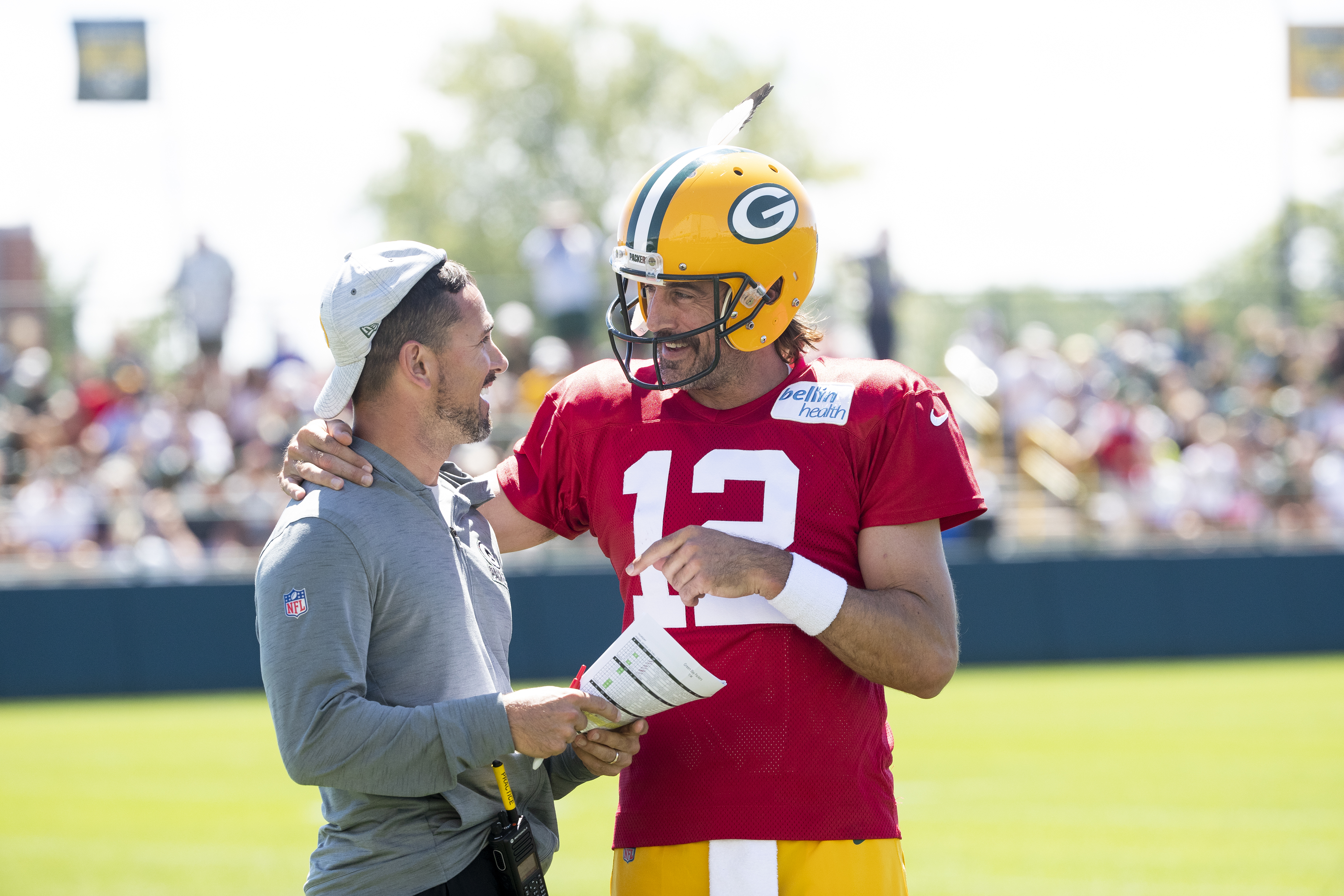 Green Bay Packers quarterback Aaron Rodgers (12) flips head coach Matt LaFleur's hat backwards during NFL football training camp on Thursday, Aug. 4, 2022, at Ray Nitschke Field in Ashwaubenon, Wis.