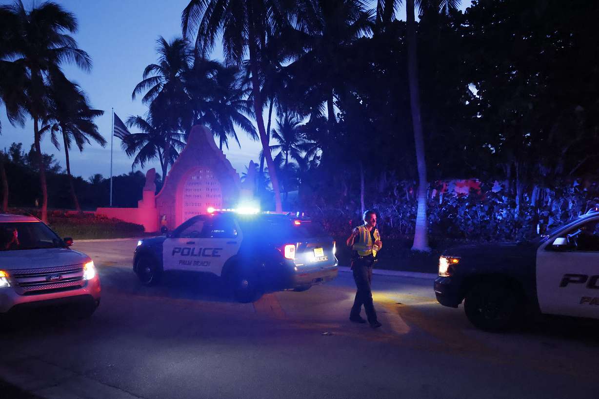 Police direct traffic outside an entrance to former President Donald Trump's Mar-a-Lago estate, Monday, in Palm Beach, Fla.