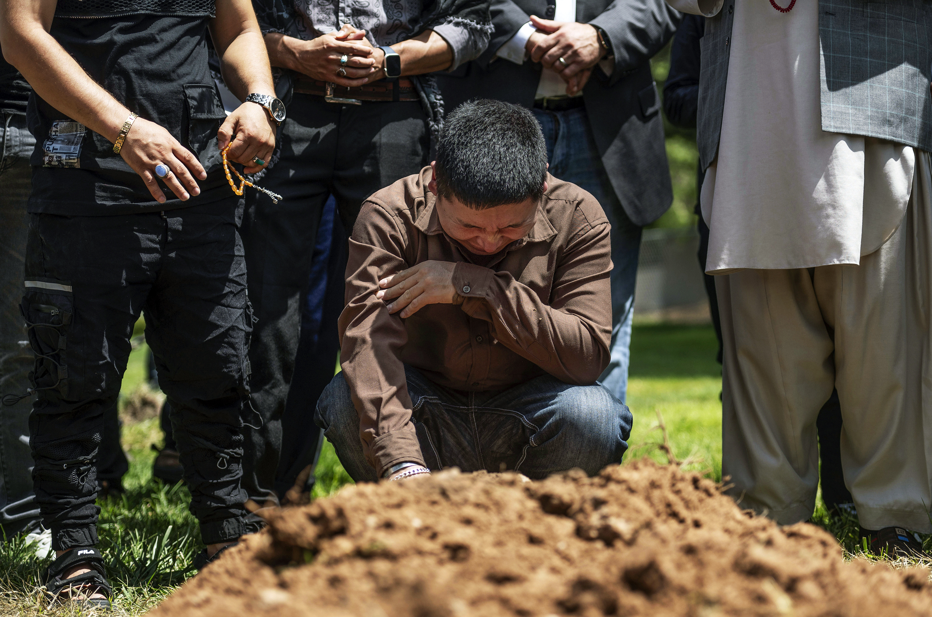 Altaf Hussain cries over the grave of his brother Aftab Hussein at Fairview Memorial Park in Albuquerque, N.M., on Friday. Authorities have charged a 51-year-old man in the killings of two Muslim men in New Mexico's largest city, and he is suspected of slaying two others.
