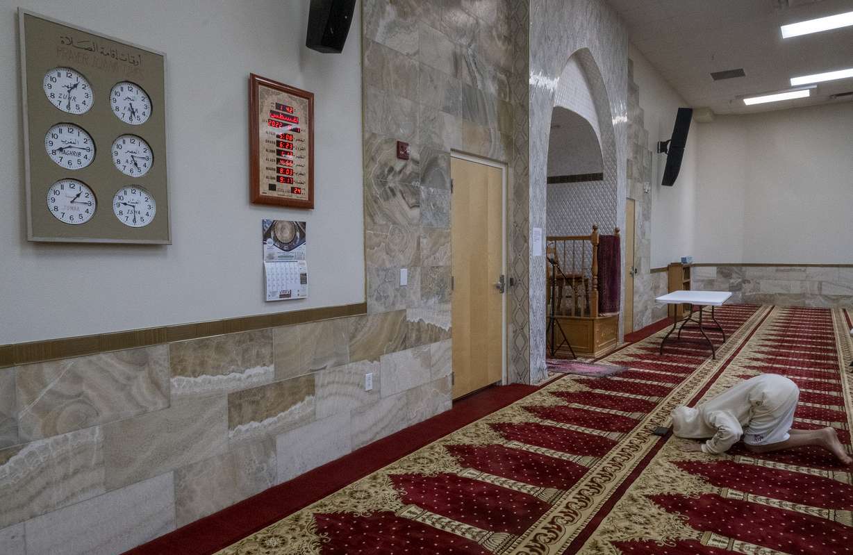 A young man bows during the Dhuhr afternoon prayer at the Islamic Center of New Mexico, Sunday, after the fourth Muslim man was murdered in Albuquerque.