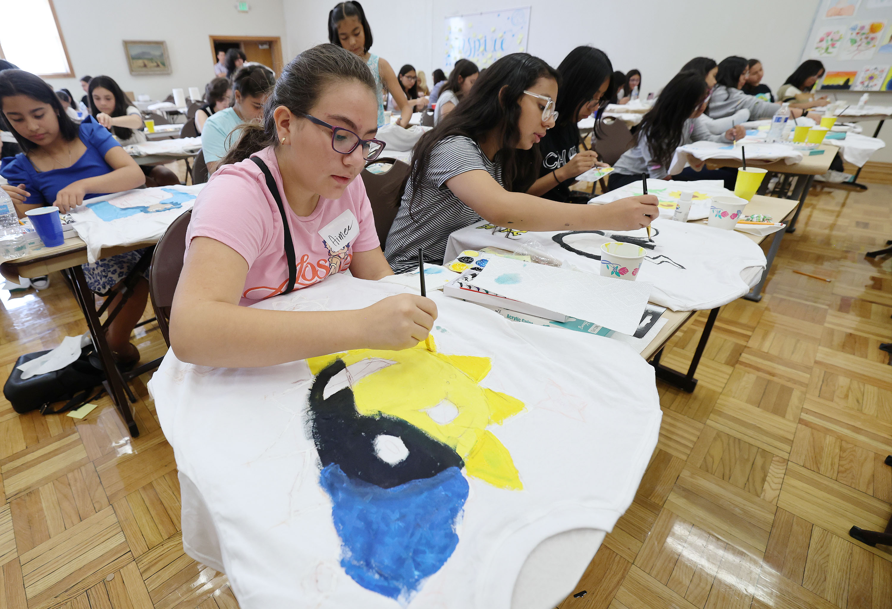Aimee Maciel paints a design on a shirt as she participates in the Ella Rises Summer Summit in Provo on Tuesday, Aug. 9, 2022. Ella Rises works with Latina youth to continue their education and preserve their cultural heritage.