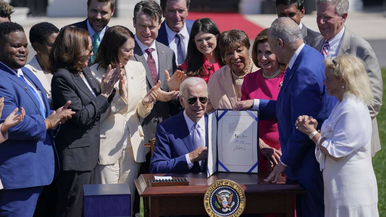 President Joe Biden holds the “CHIPS and Science Act of 2022” after signing it during a ceremony on the South Lawn of the White House, Tuesday, in Washington.
