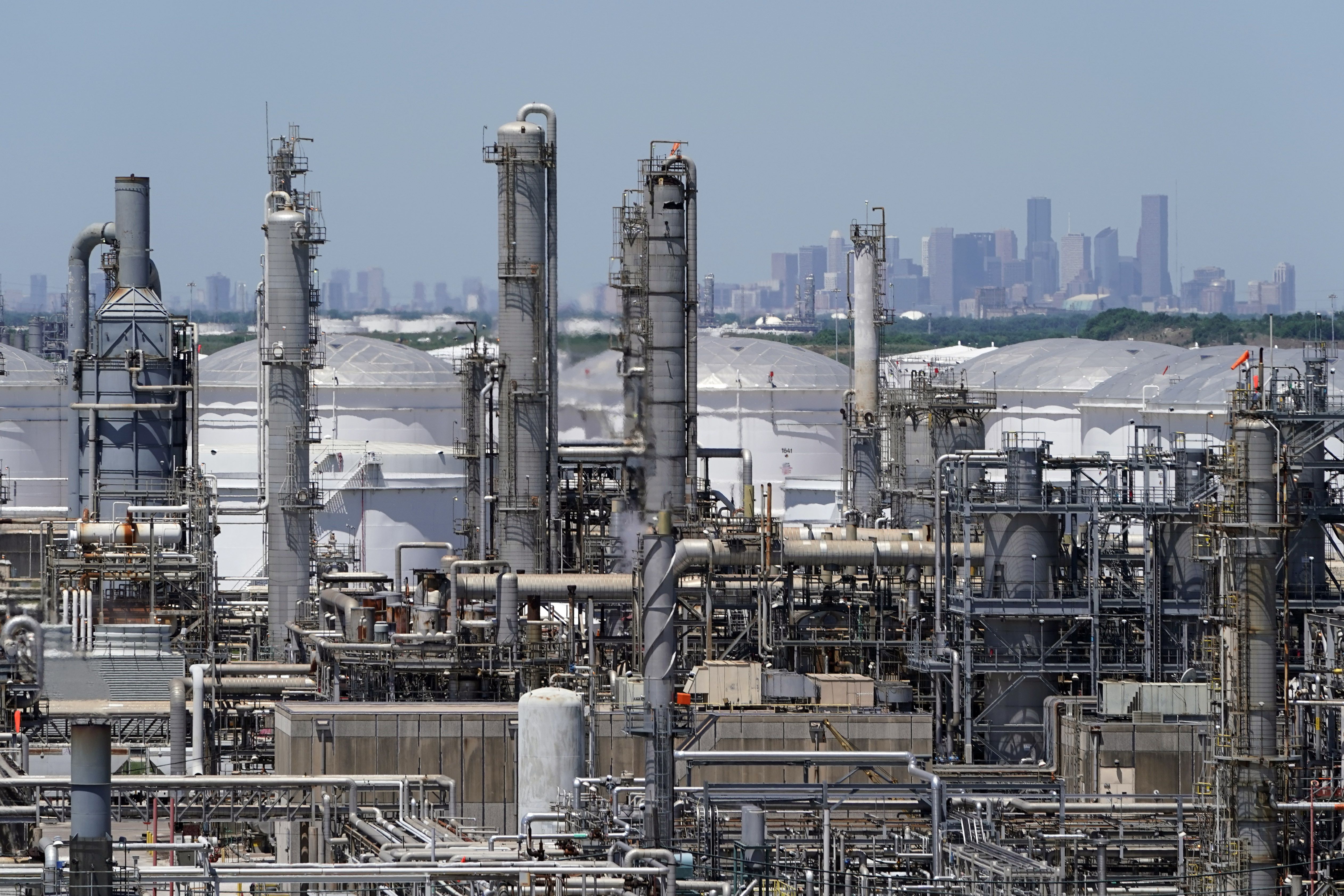 A refinery along the Houston Ship Channel is seen with downtown Houston in the background on April 30, 2020. Billions of dollars in climate and environment investments from the Inflation Reduction Act could flow to communities in the United States that have been plagued by pollution and climate threats for decades.