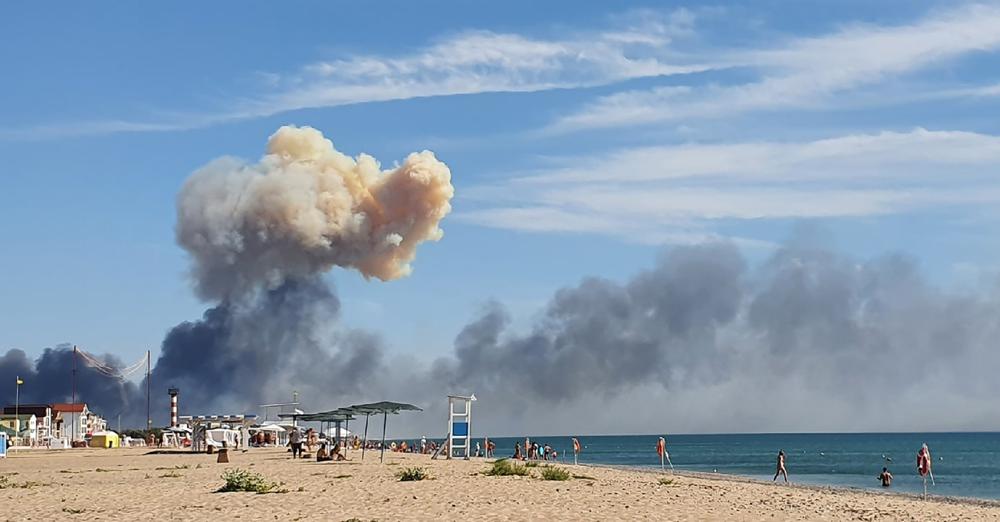 Rising smoke can be seen from the beach at Saky after explosions were heard from the direction of a Russian military airbase near Novofedorivka, Crimea, Tuesday. The explosion of munitions caused a fire at a military air base in Russian-annexed Crimea Tuesday but no casualties or damage to stationed warplanes, Russia's Defense Ministry said. 