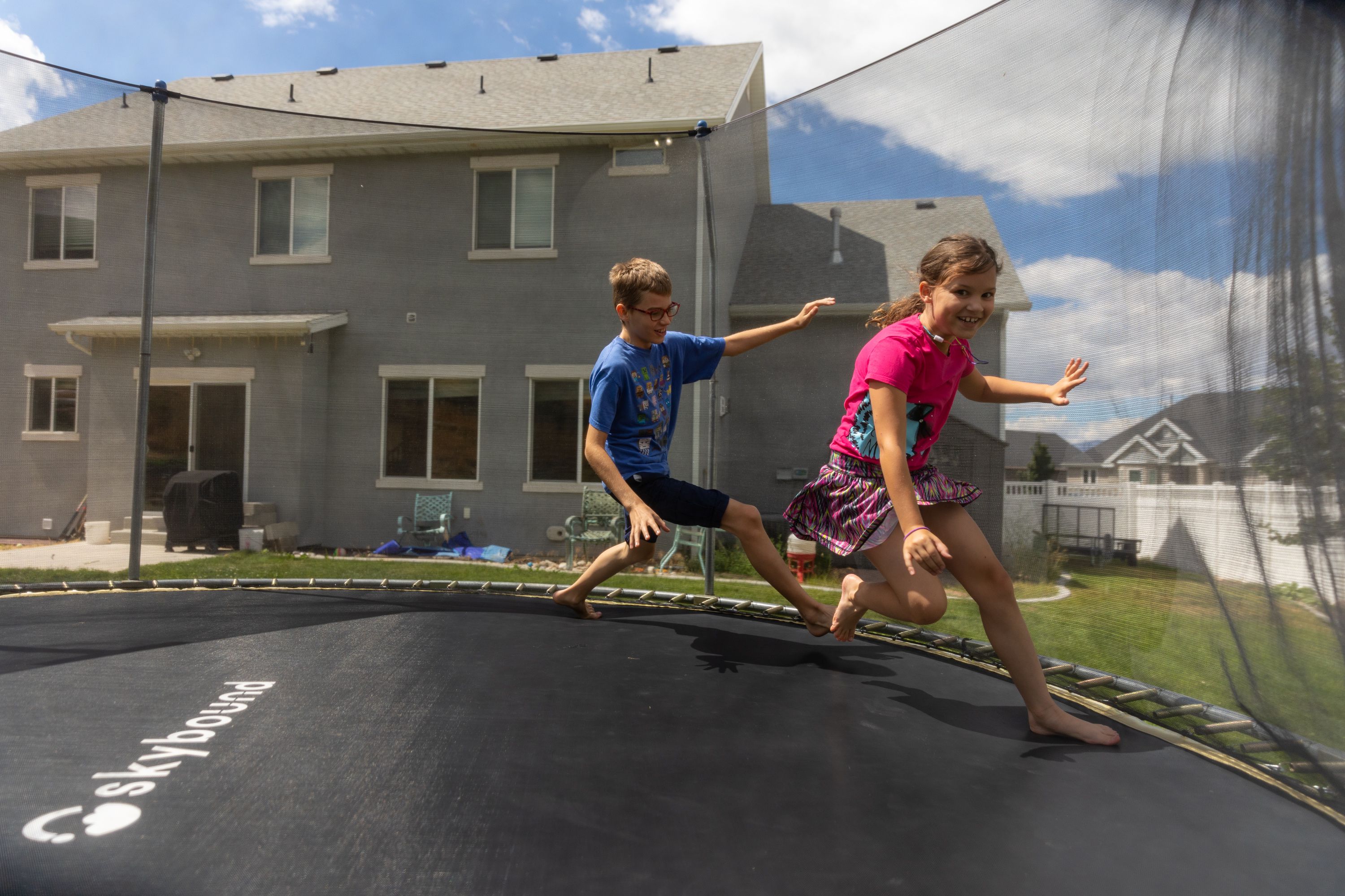Justin Cox, 11, chases his sister, Ruth, 9, during a game of tag in their backyard in Lindon on Saturday. Rising property values in Utah have led to property tax hikes as well.