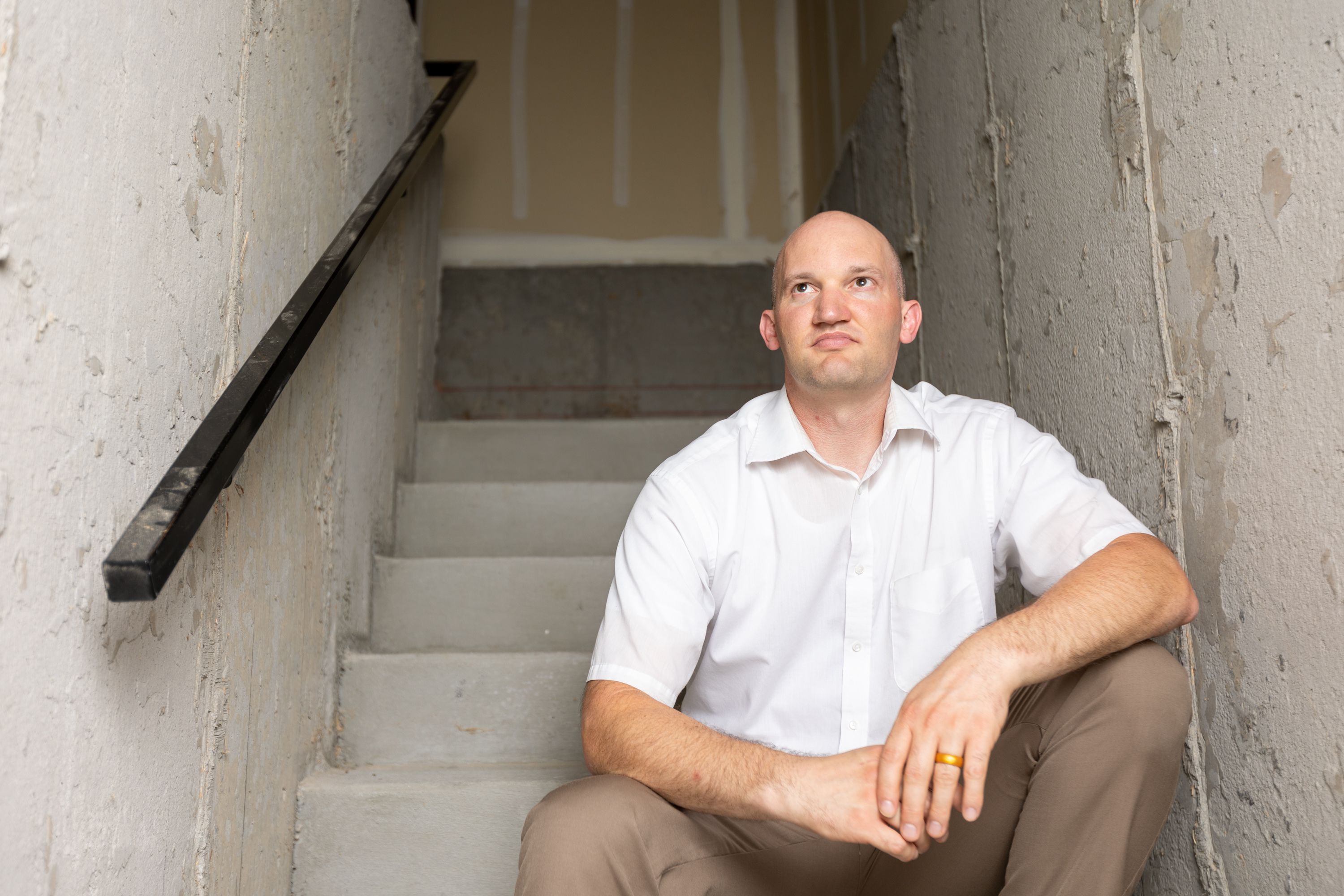 Seth Cox sits on a staircase that leads to his three-car garage at his home in Lindon on July 31. Rising property values in Utah have led to property tax hikes as well.