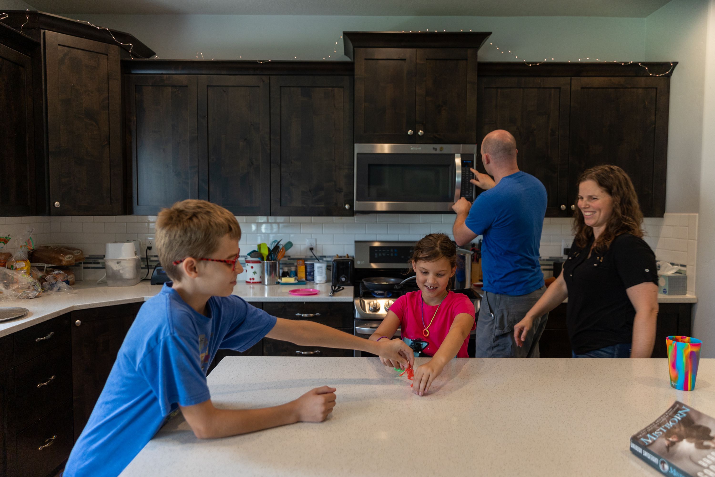 Justin Cox, 11, plays with his sister, Ruth, 9, as their dad, Seth, warms up leftovers and their mom, Carolyn, walks by in their kitchen in Lindon on Saturday. Rising property values in Utah have led to property tax hikes as well.