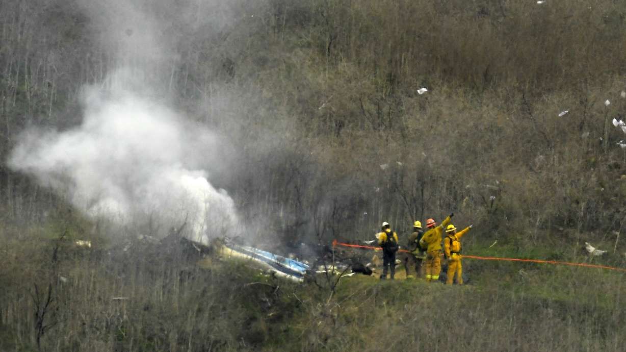 FILE - Firefighters work the scene of a helicopter crash where former NBA basketball star Kobe Bryant died in Calabasas, Calif., Jan. 26, 2020. Bryant's widow is taking her lawsuit against the Los Angeles County Sheriff's Department and Fire Department to a federal jury seeking compensation for photos deputies shared of the remains of the NBA star, his daughter and seven others killed in a helicopter crash in 2020.