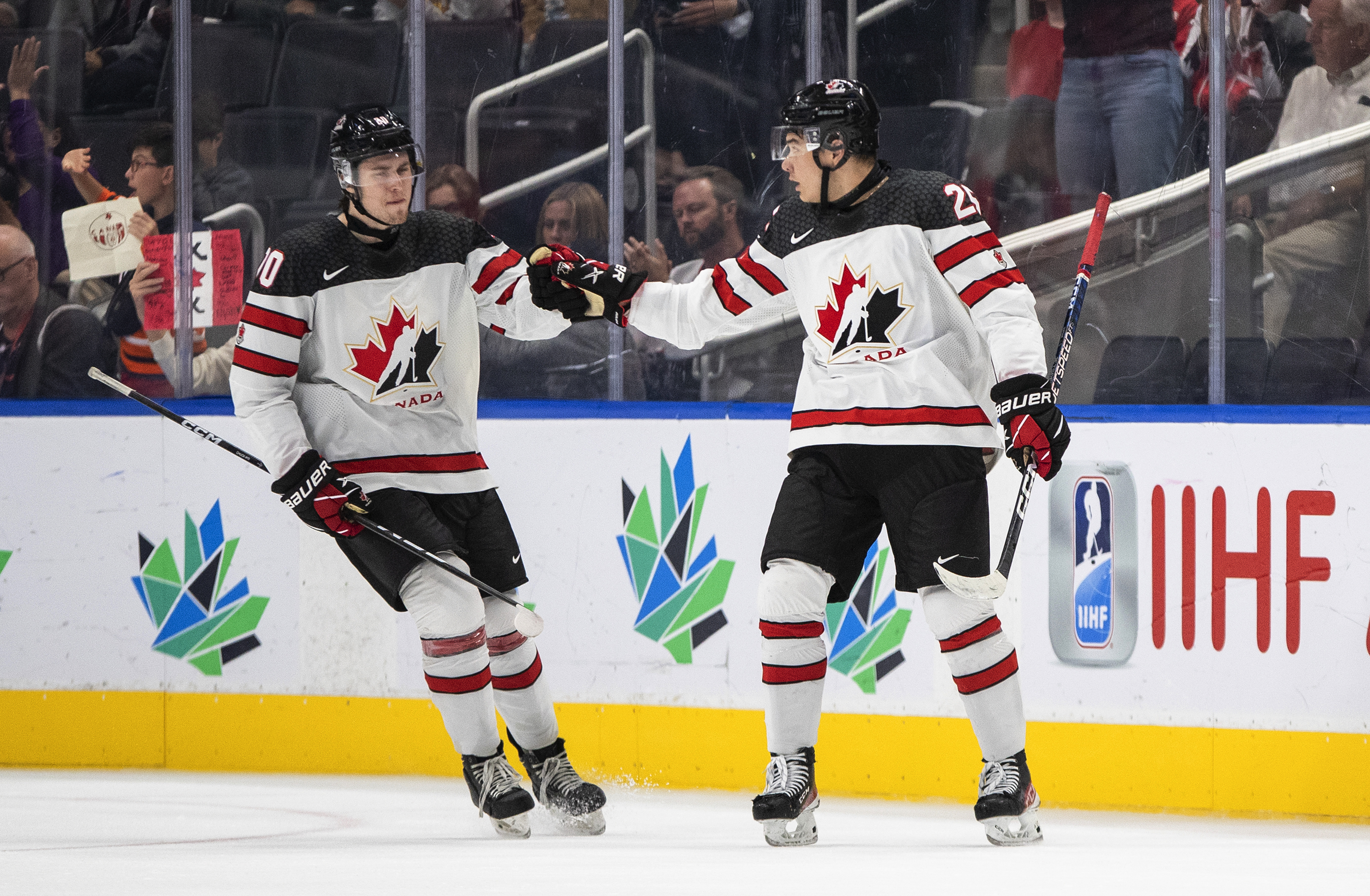 Canada's Zack Ostapchuk (20) and William Dufour (25) celebrate a goal against Latvia during the third period of an IIHF junior world hockey championships game Wednesday, Aug. 10, 2022, in Edmonton, Alberta.