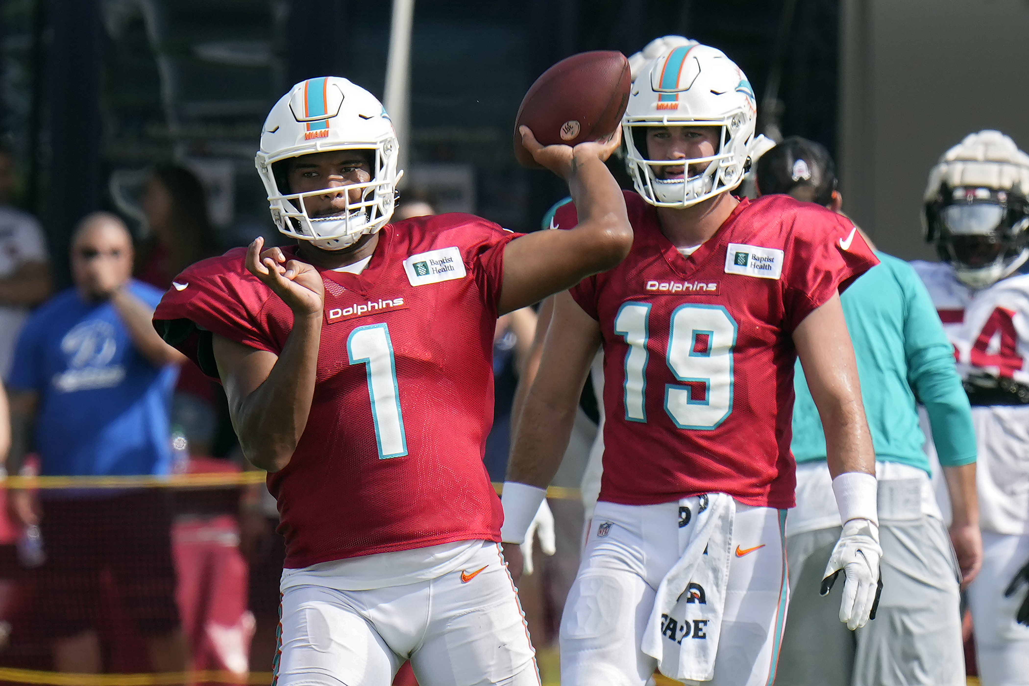 Miami Dolphins quarterback Tua Tagovailoa (1) throws a pass during an NFL football training camp practice with the Tampa Bay Buccaneers Wednesday, Aug. 10, 2022, in Tampa, Fla. Looking on is quarterback Skylar Thompson (19). 