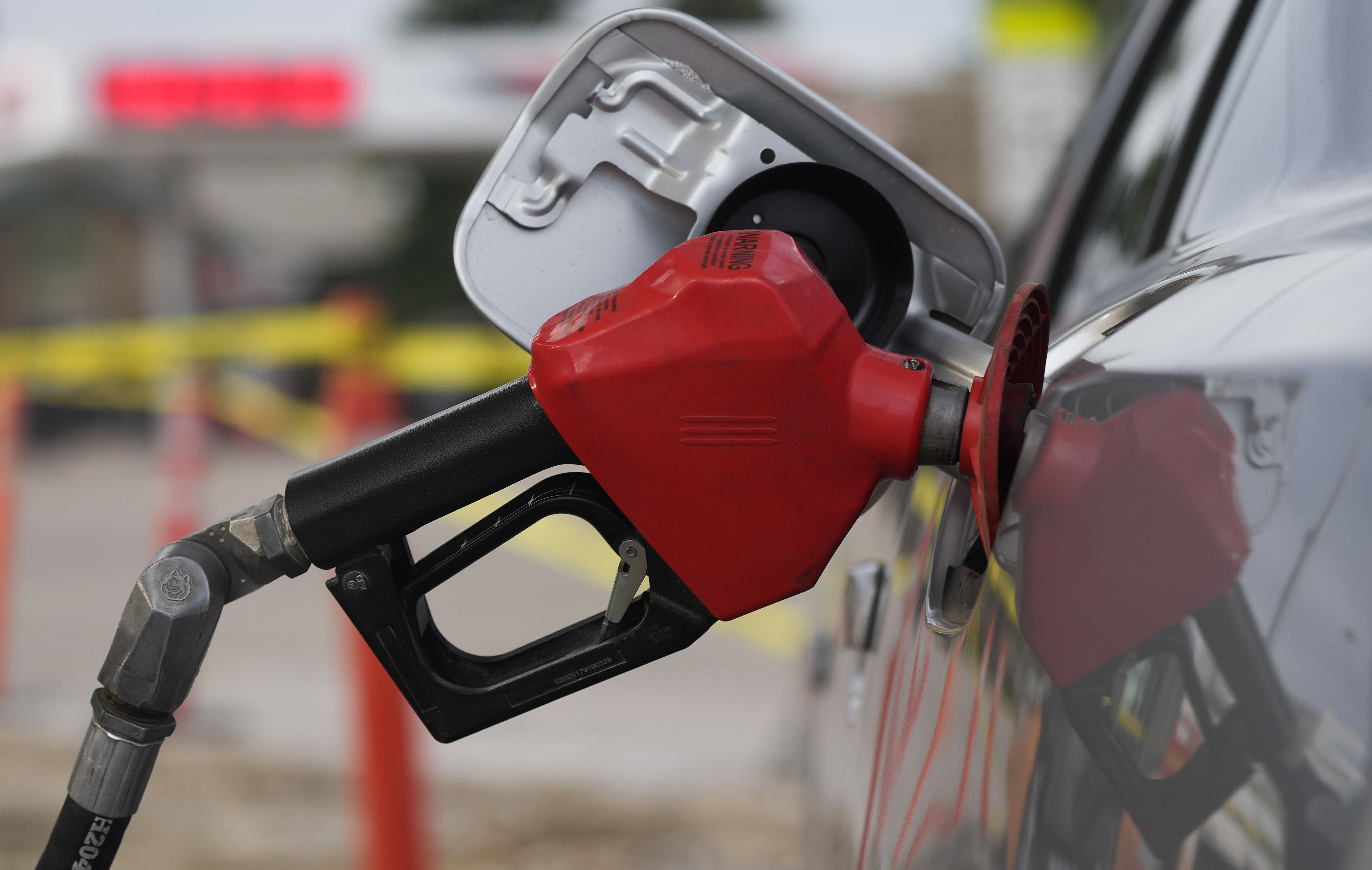 A motorist fills up the tank on a sedan, on July 22, in Saratoga, Wyo. Gasoline prices are sliding back toward the $4 mark for the first time in more than five months.