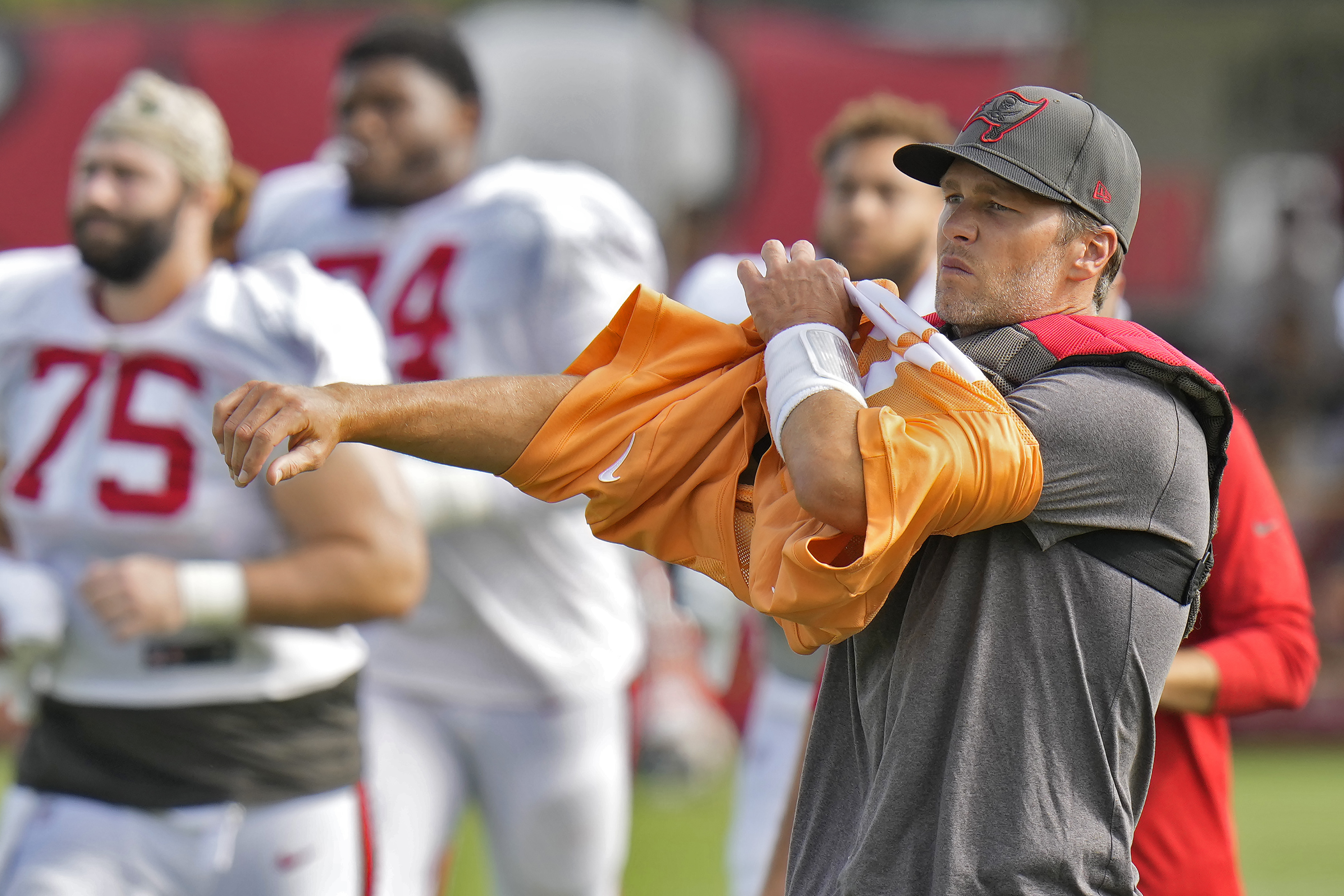 Tampa Bay Buccaneers quarterback Tom Brady puts on his jersey during an NFL football training camp practice with the Miami Dolphins Wednesday, Aug. 10, 2022, in Tampa, Fla.